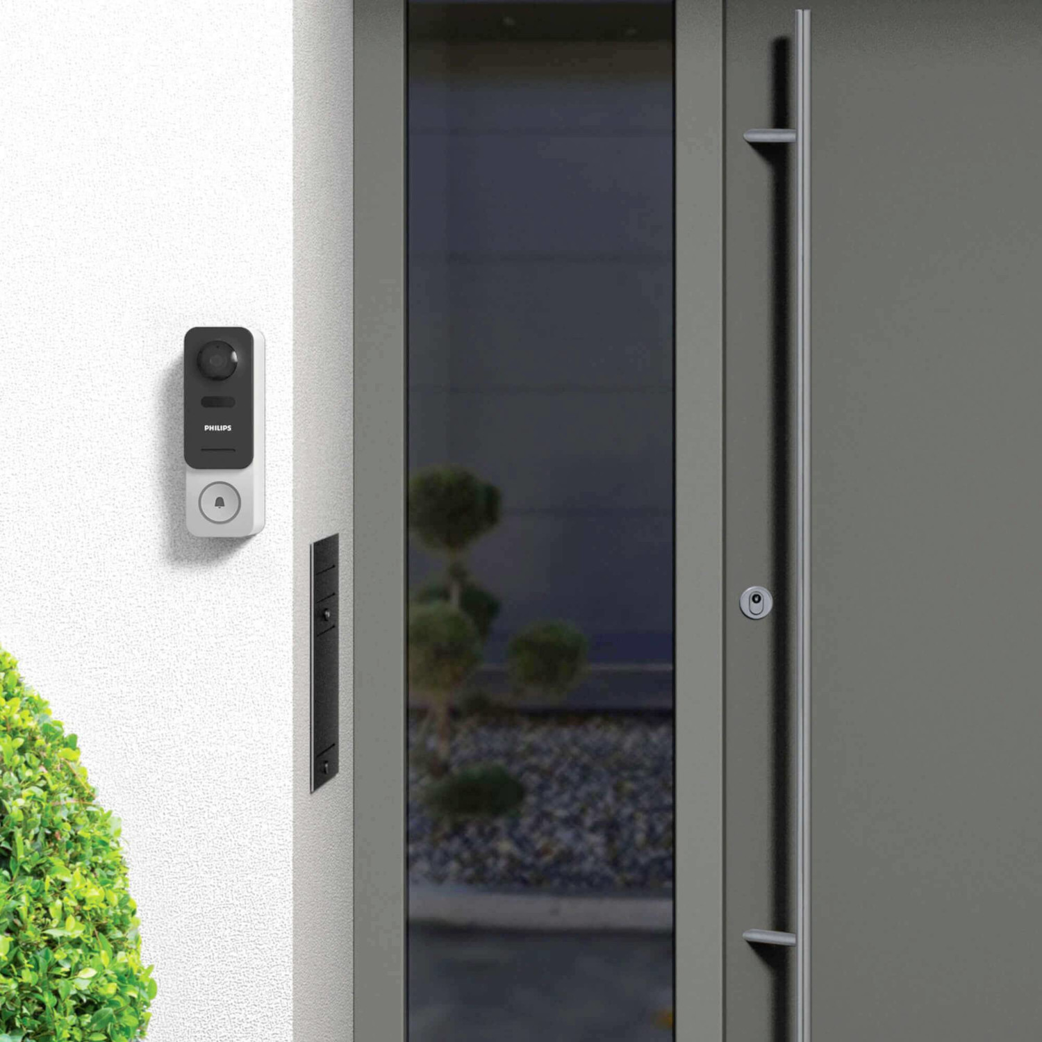 White wall with smart doorbell and black plate. Door is on the right.