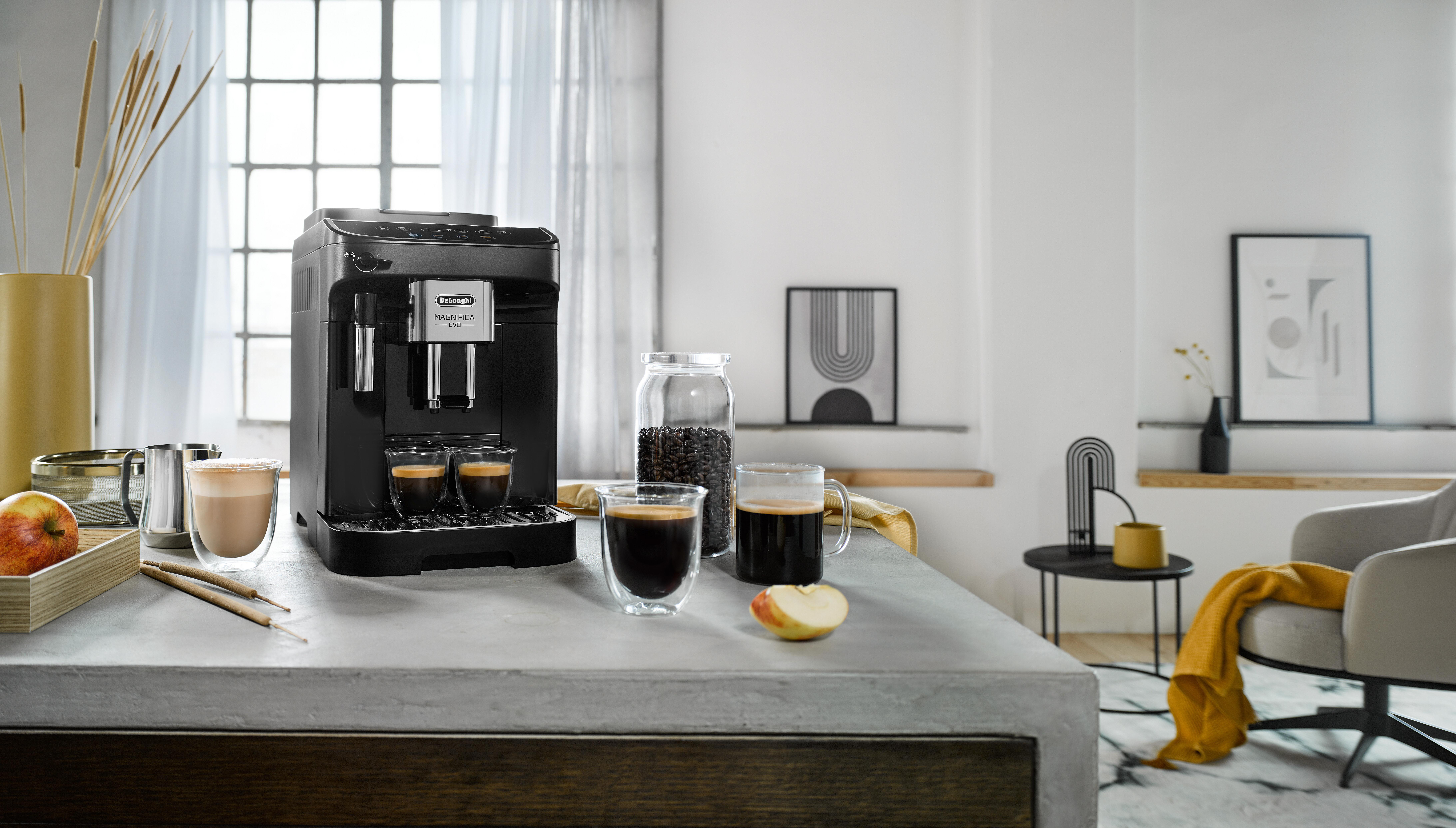 Eine schwarze Kaffeemaschine mit Kaffeegläsern und einem Glas Kaffeebohnen.