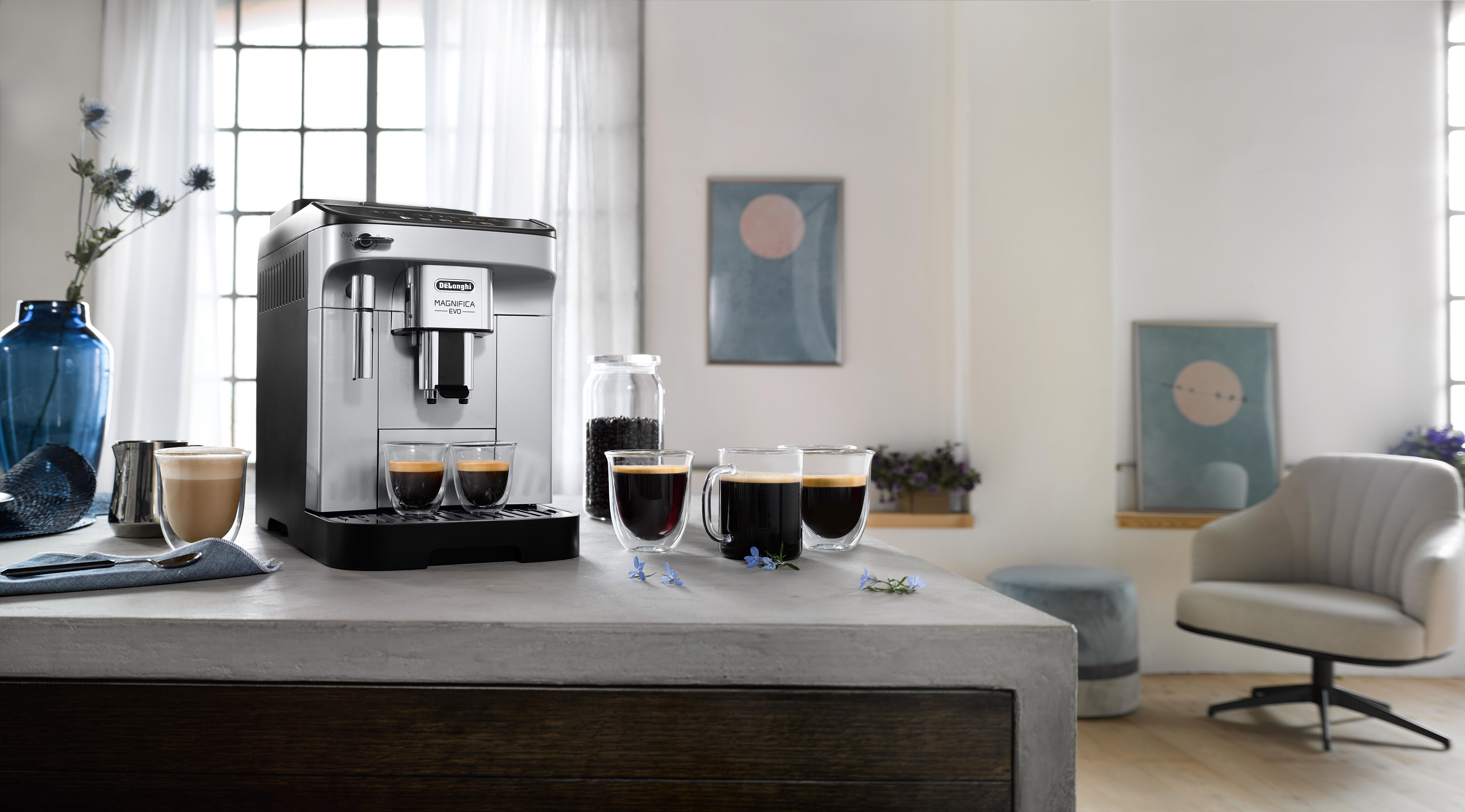 Eine Kaffeemaschine mit zwei Tassen Kaffee und einigen Gegenständen auf dem Tisch.
