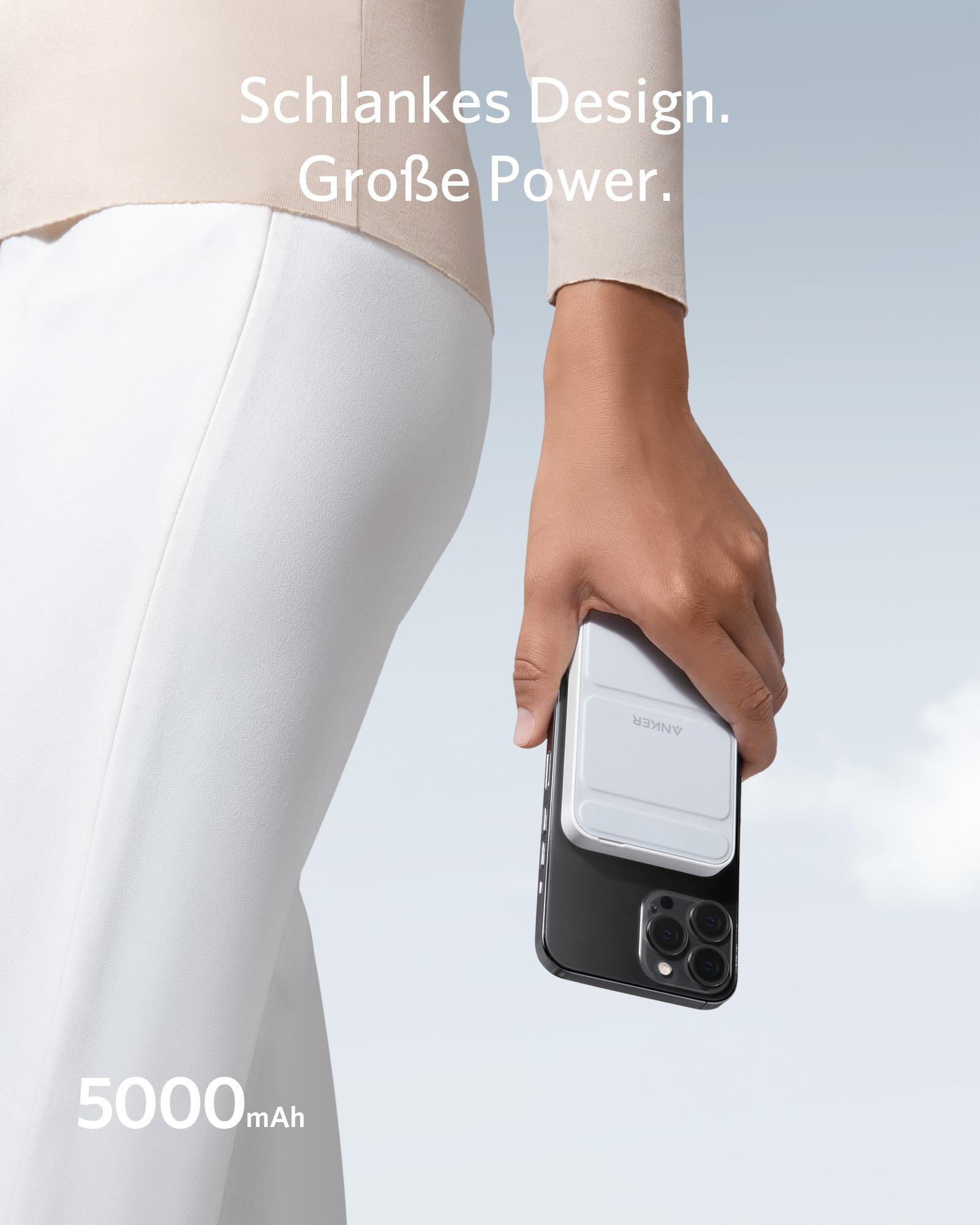 Eine Person, die ein schwarzes Telefon mit einem weißen Ladegerät hält.