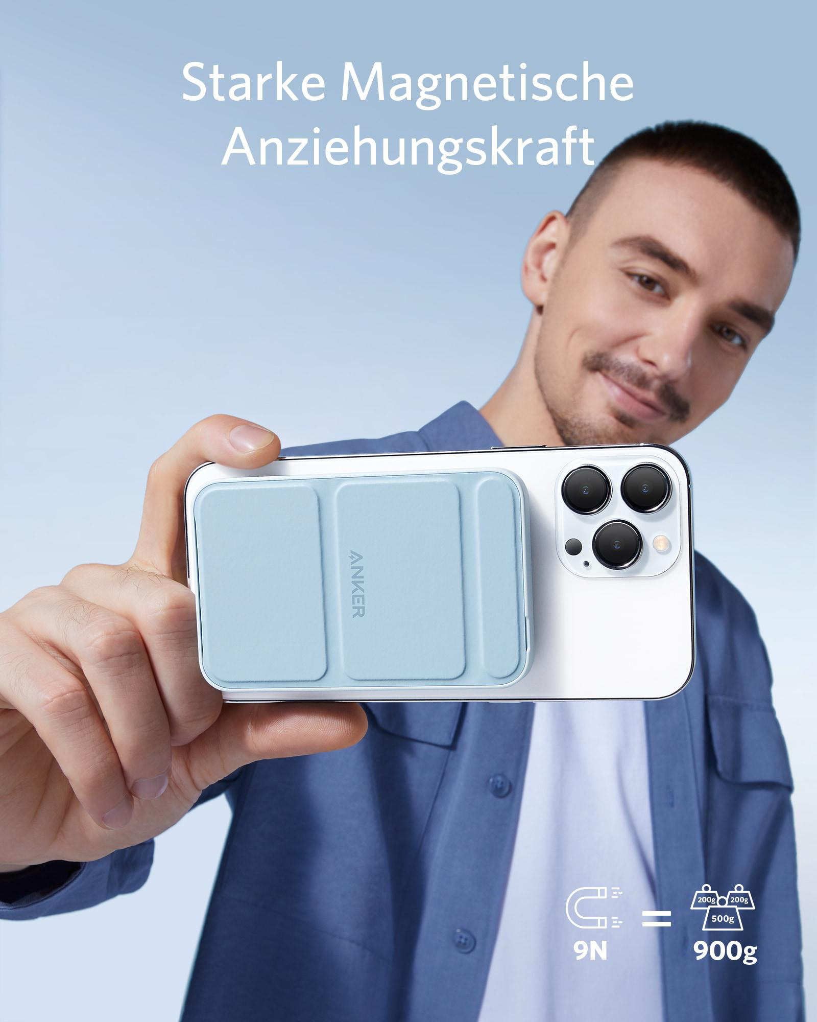Eine Person hält eine blaue Anker Powerbank, die an einem weißen Telefon befestigt ist.