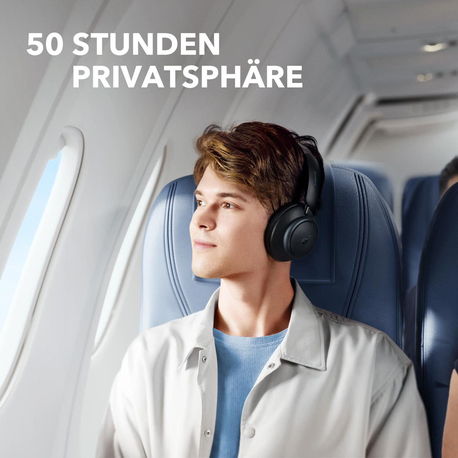 Ein Mann mit schwarzen Kopfhörern in einem Flugzeug, der aus dem Fenster schaut. Text sagt 50 Stunden Privatsphäre.