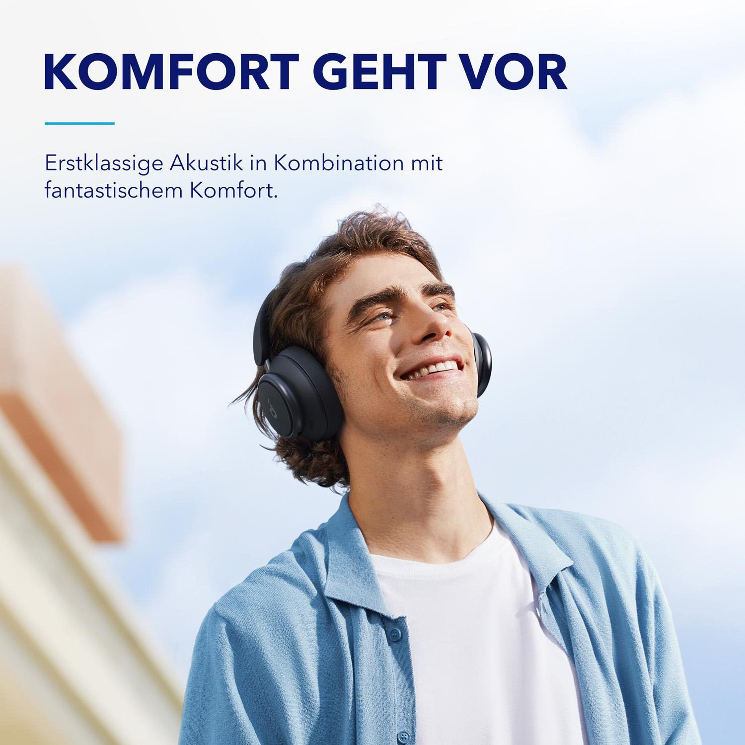 Ein Mann mit schwarzen Kopfhörern lächelt. Text auf Deutsch oben.