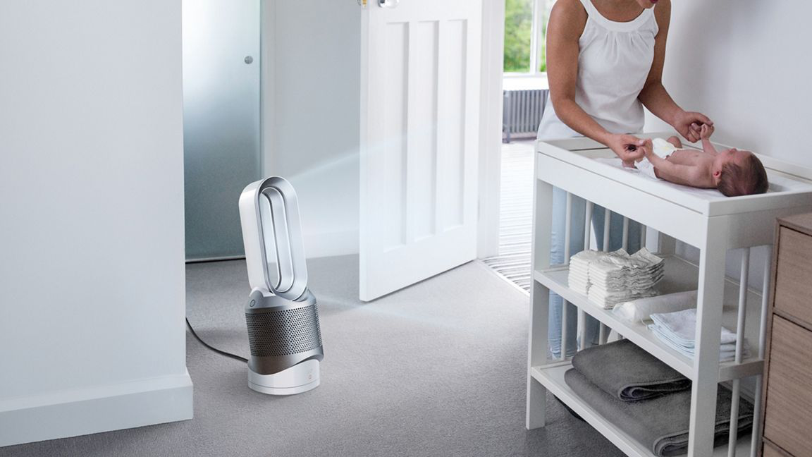 Ein Baby liegt auf einem Wickeltisch, im Hintergrund steht ein Ventilator.