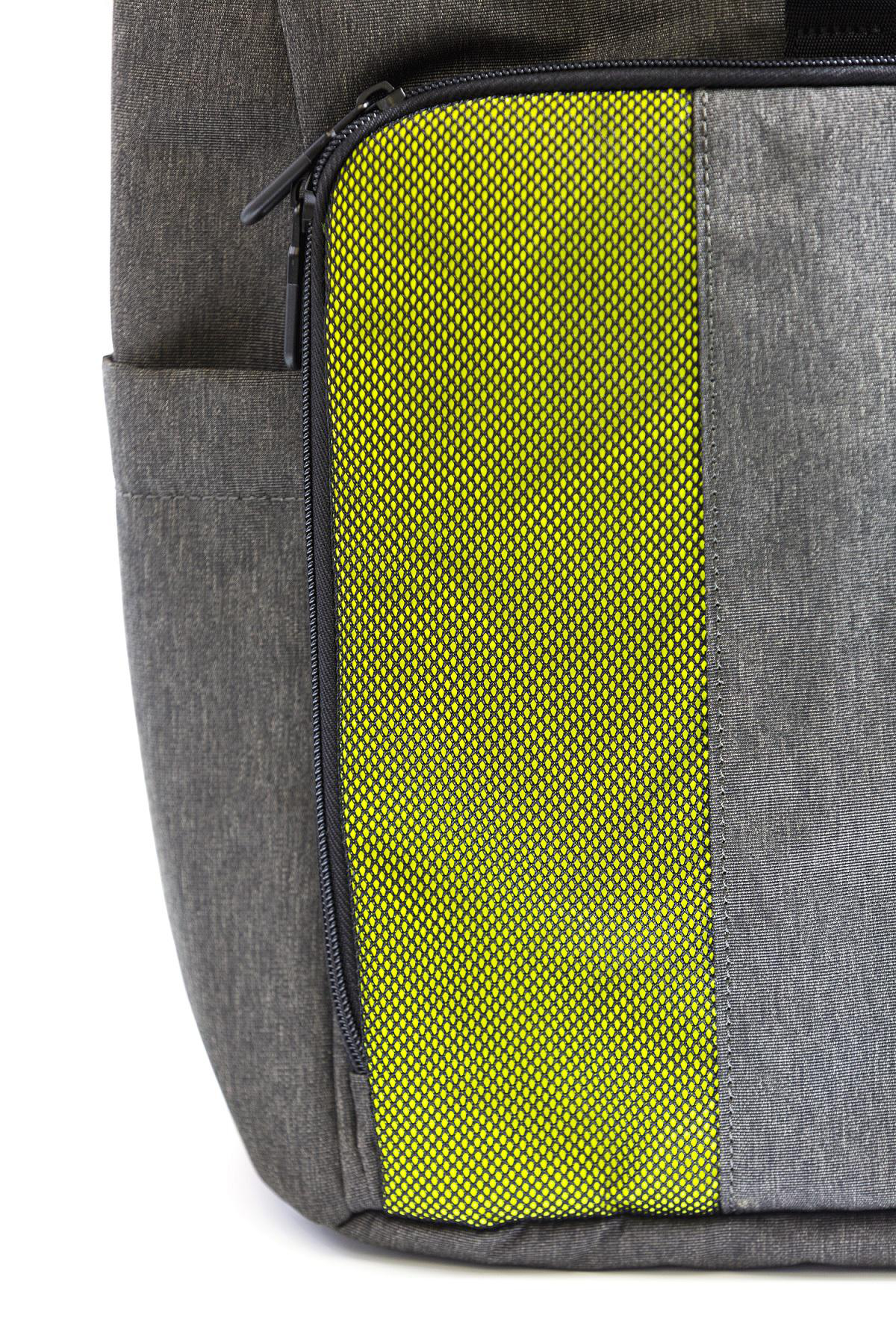 Nahaufnahme eines grauen Rucksacks mit gelbem Mesh-Bereich und einem schwarzen Reißverschluss.