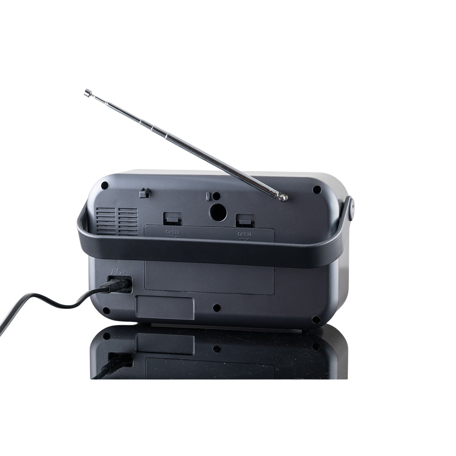 Een grijze radio met een zwart handvat en een zilveren antenne, op een zwart reflecterend oppervlak.