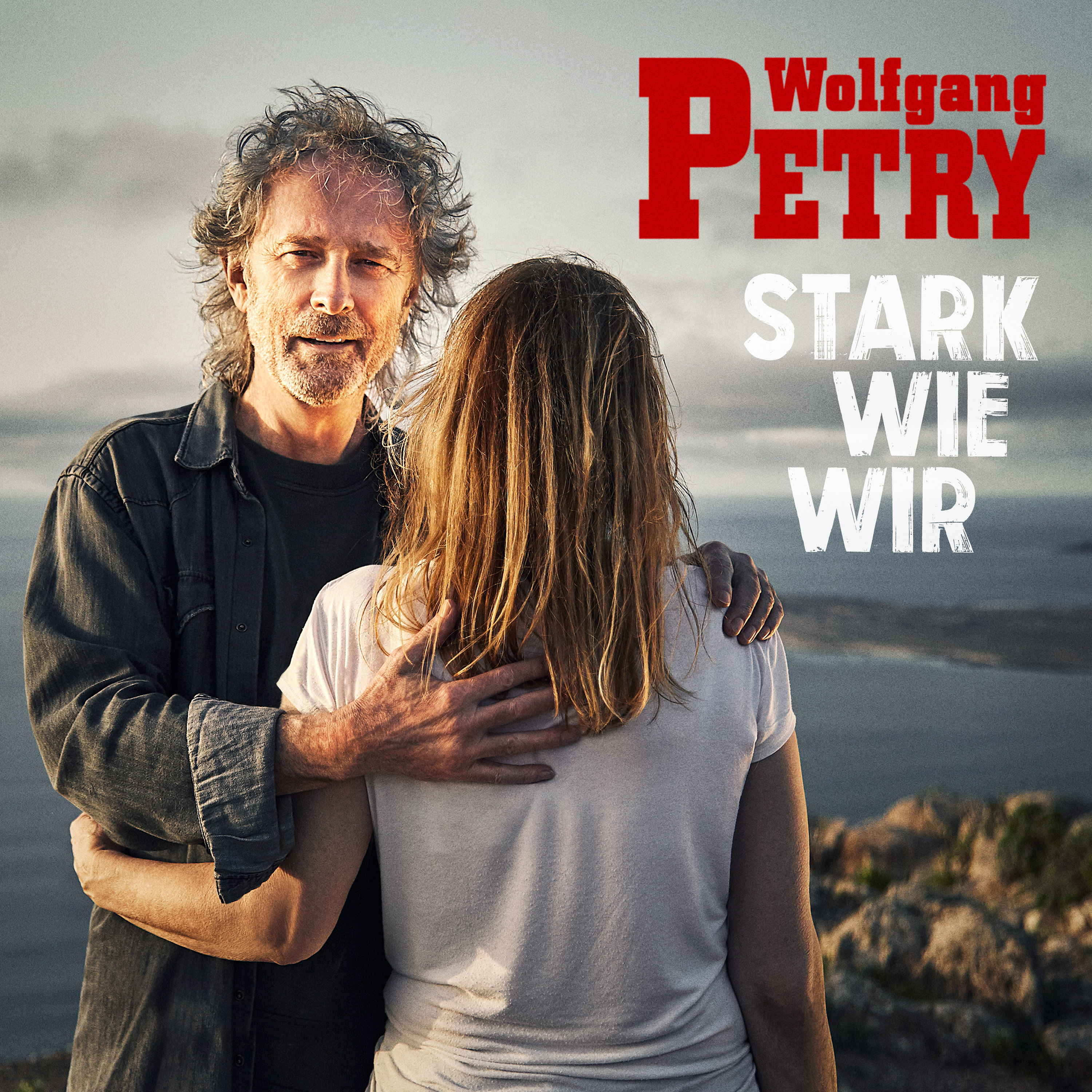 Mann umarmt Frau, Text 'Wolfgang Petry' und 'Stark Wie Wir'.