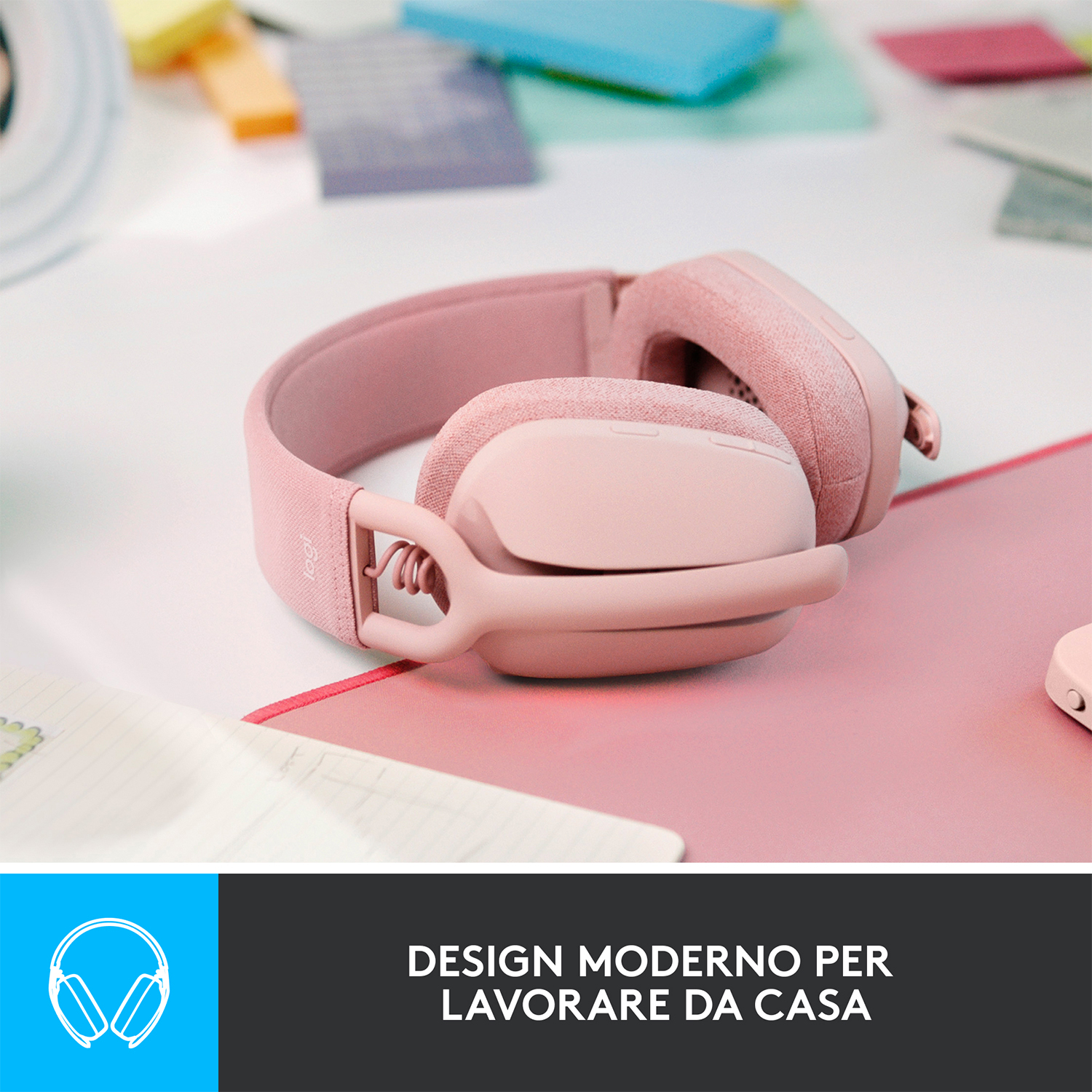 Cuffie rosa su una superficie rosa con un blocco note e post-it.