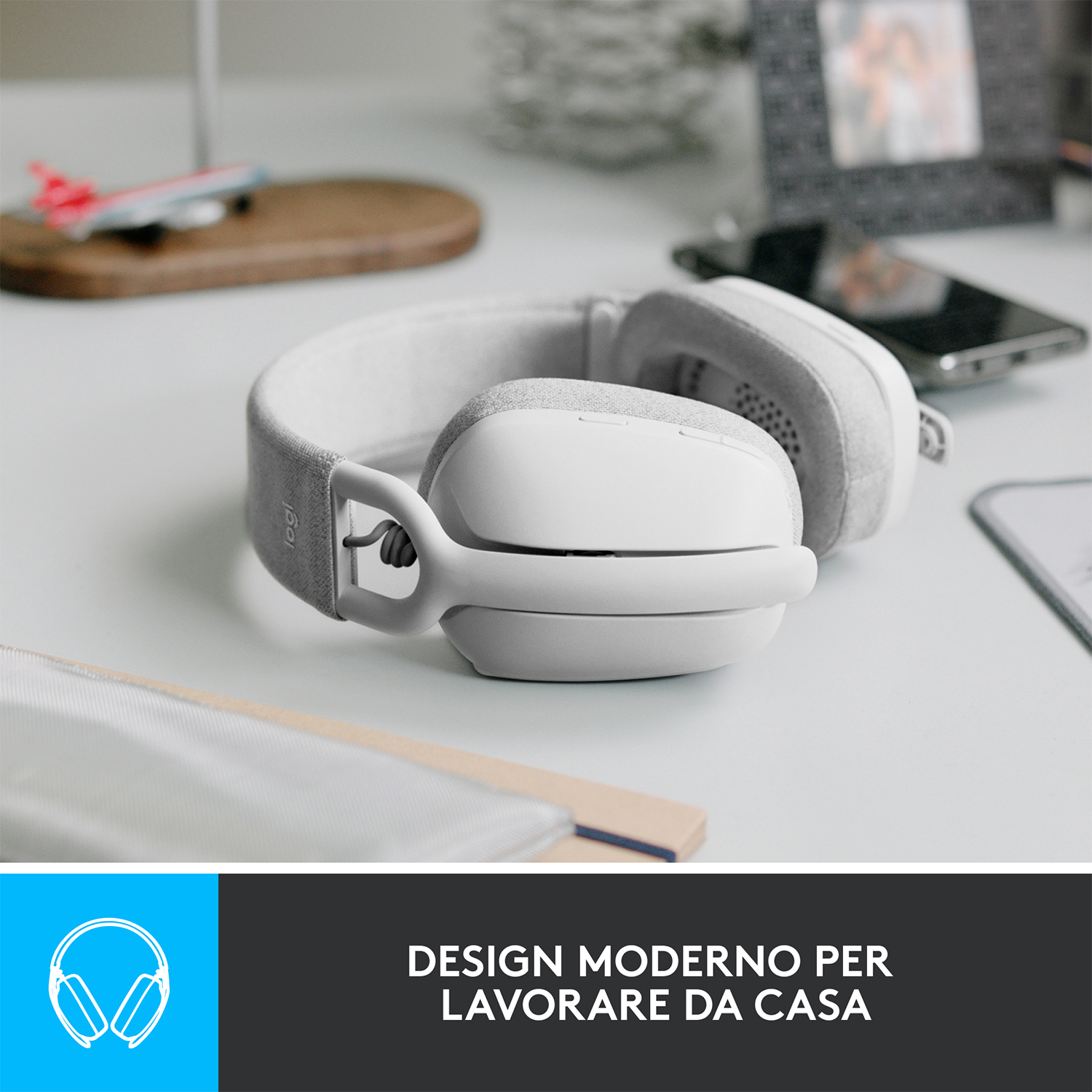 Cuffie bianche su un tavolo bianco. Il testo recita: Design moderno per lavorare da casa.