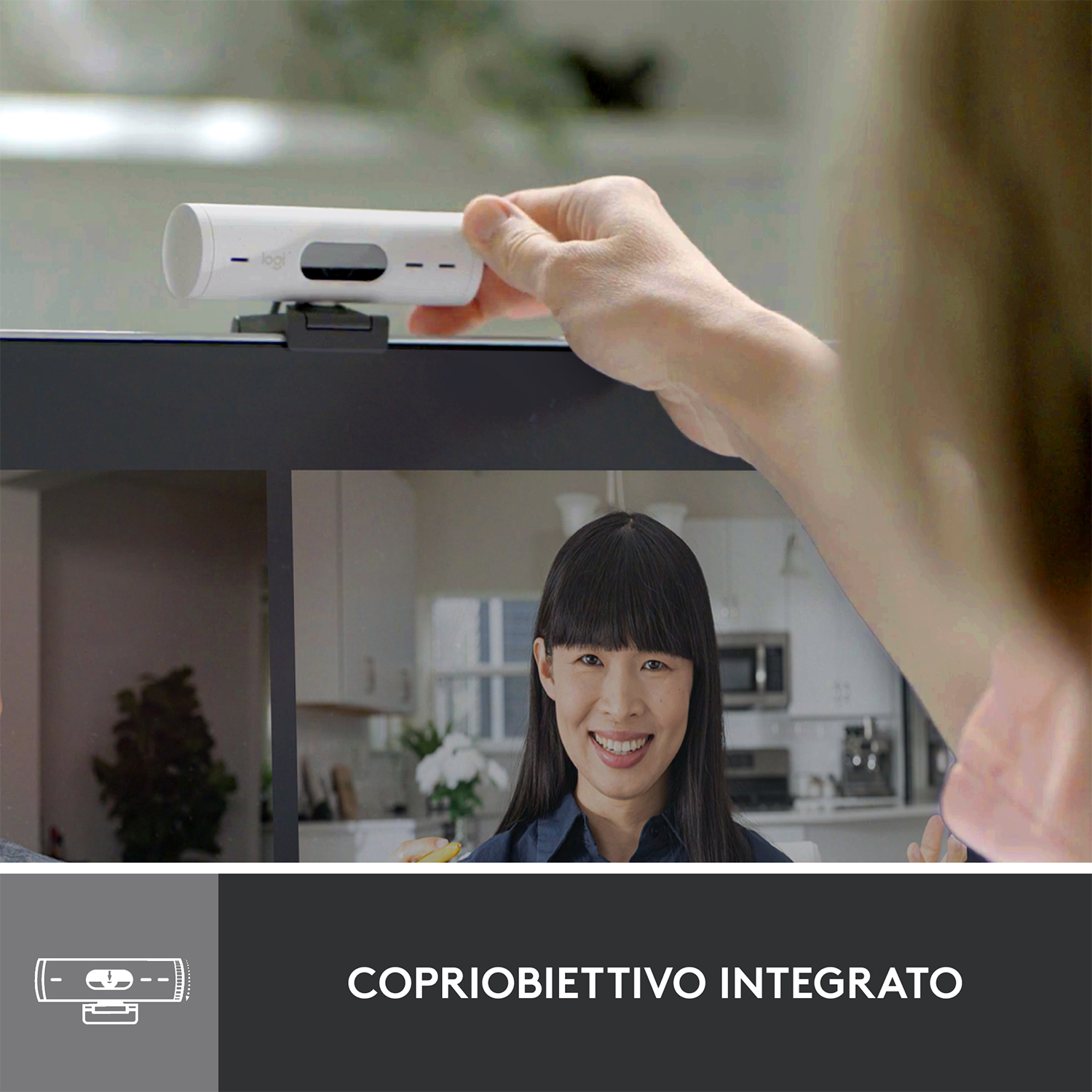 Mano che regola una webcam su un monitor, con una donna sorridente sullo schermo.
