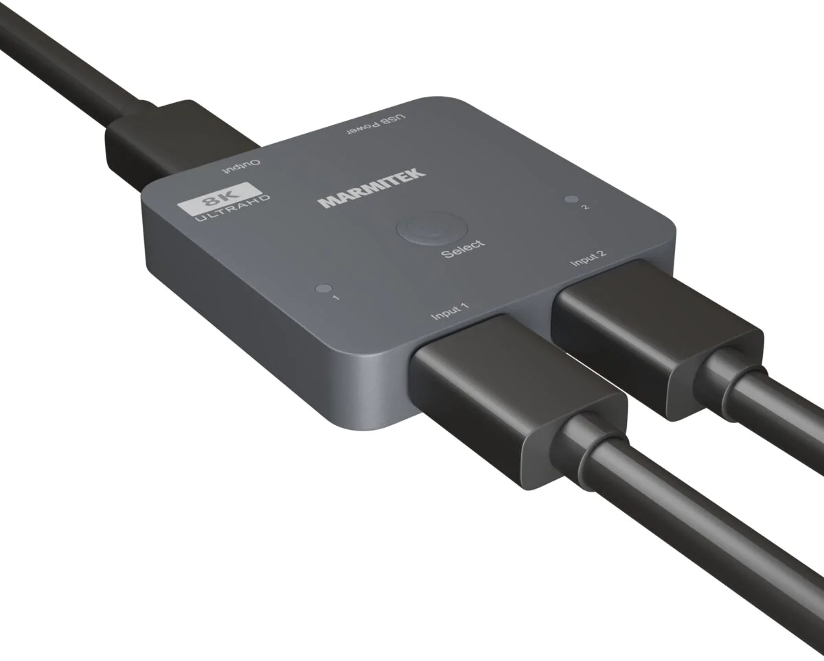 Un commutateur HDMI gris avec câbles connectés, étiqueté pour l'entrée et la sortie.