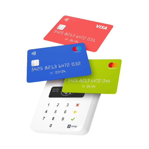 Kreditkarten in Rot, Blau und Grün, mit einem Zahlungsterminal auf einer weißen Oberfläche.