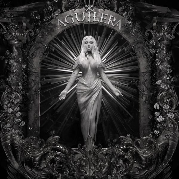Albumcover mit einer Statue einer Frau mit ausgestreckten Armen in einem dekorativen Rahmen.