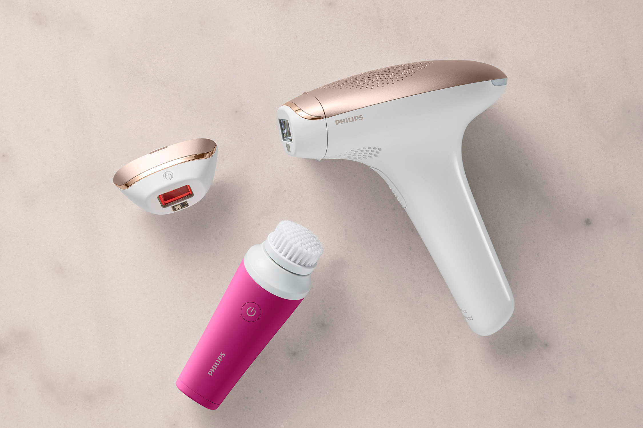 Three beauty devices: a white IPL, a pink facial brush, and a small IPL head.