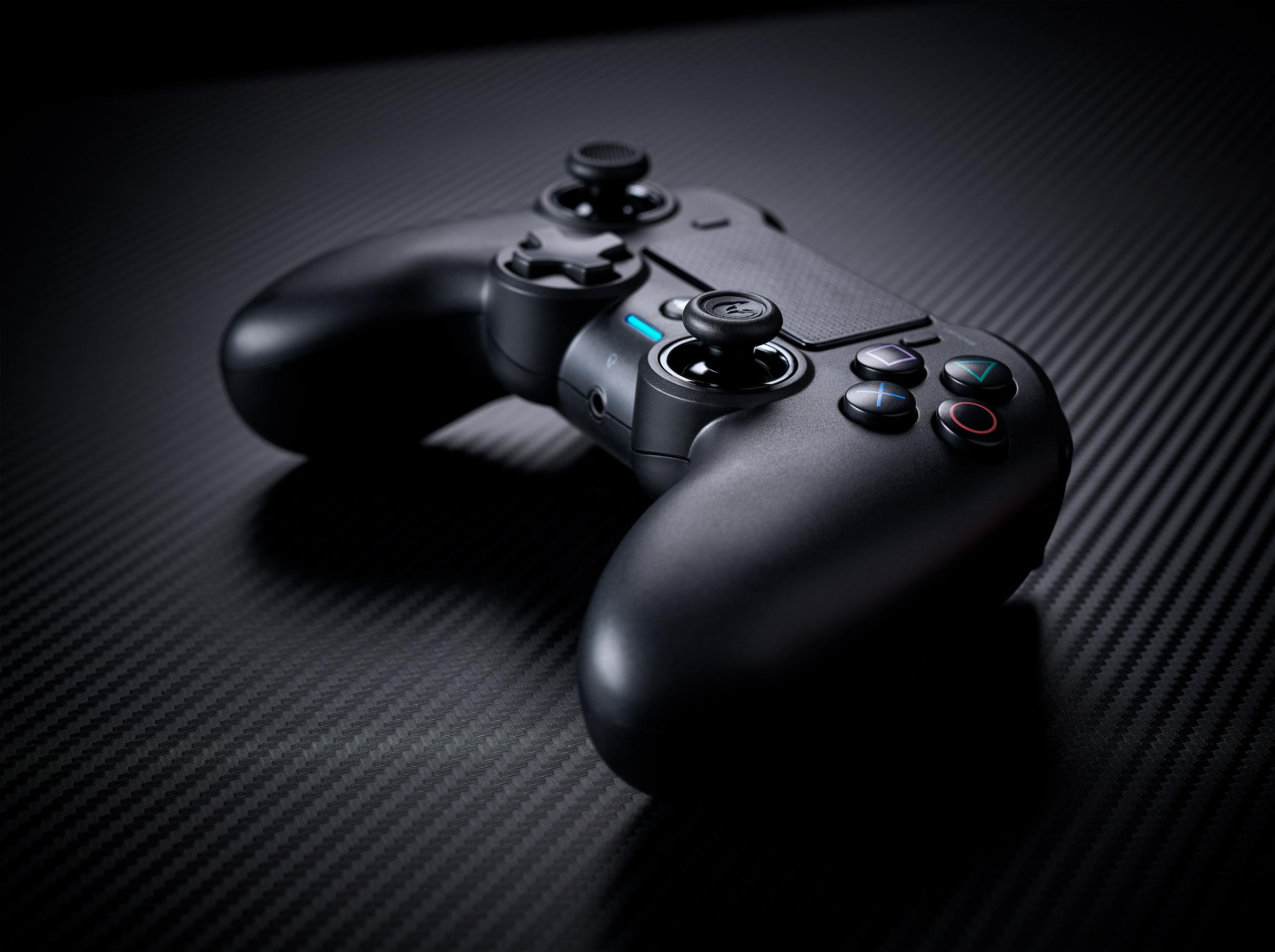 Schwarzer Gaming-Controller auf strukturierter Oberfläche. Knöpfe und Joysticks sichtbar.