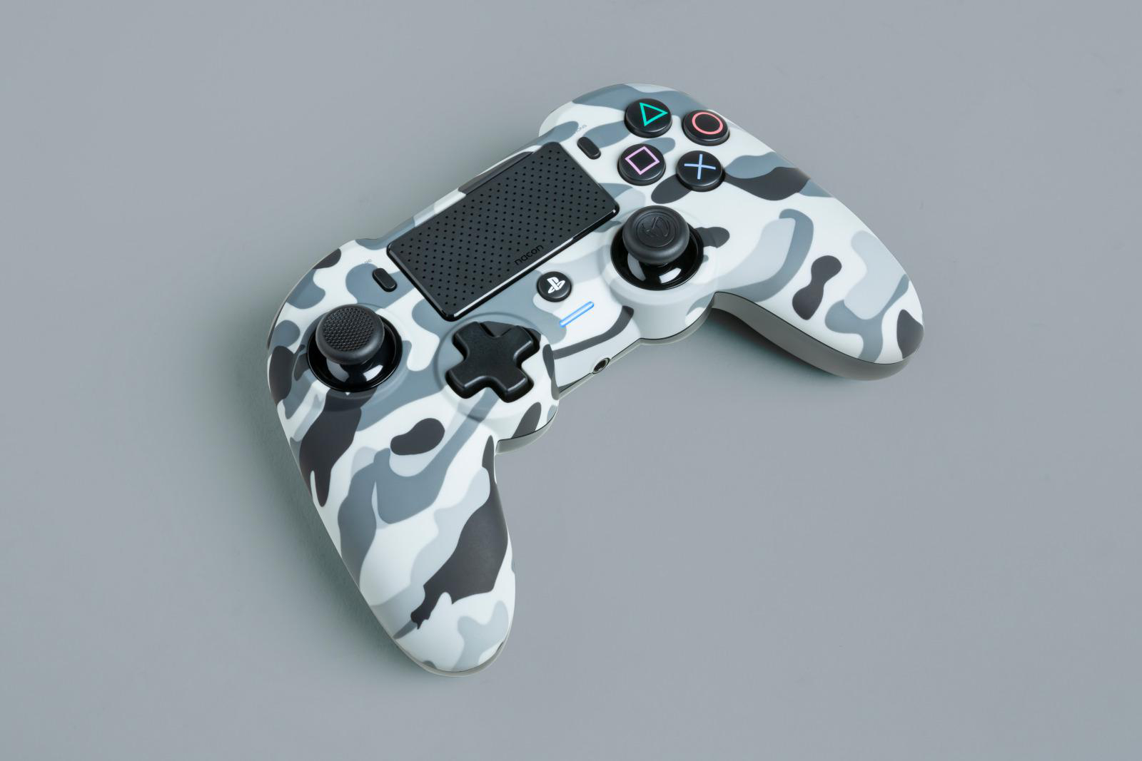 Tarnmuster-Spielcontroller auf einer grauen Oberfläche.