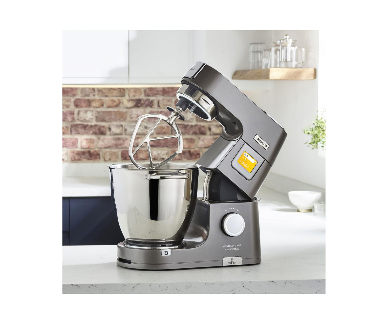 Ein grauer Kenwood Titanium Chef Patissier Küchenmixer auf einer weißen Oberfläche. Edelstahlschüssel.
