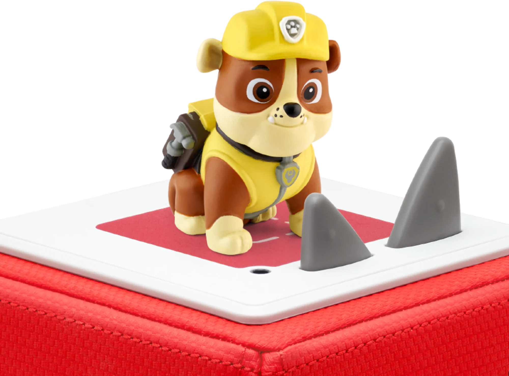 Eine Paw Patrol-Figur auf roter und weißer Basis mit Haifischflossen. Darunter befindet sich eine rote Box.