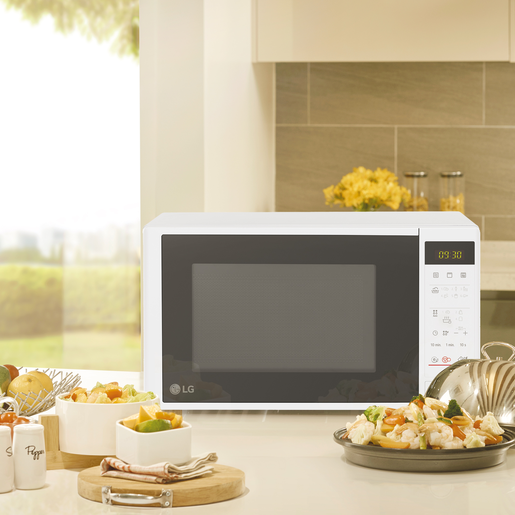 Horno microondas blanco con comida en una encimera, cerca de una ventana.