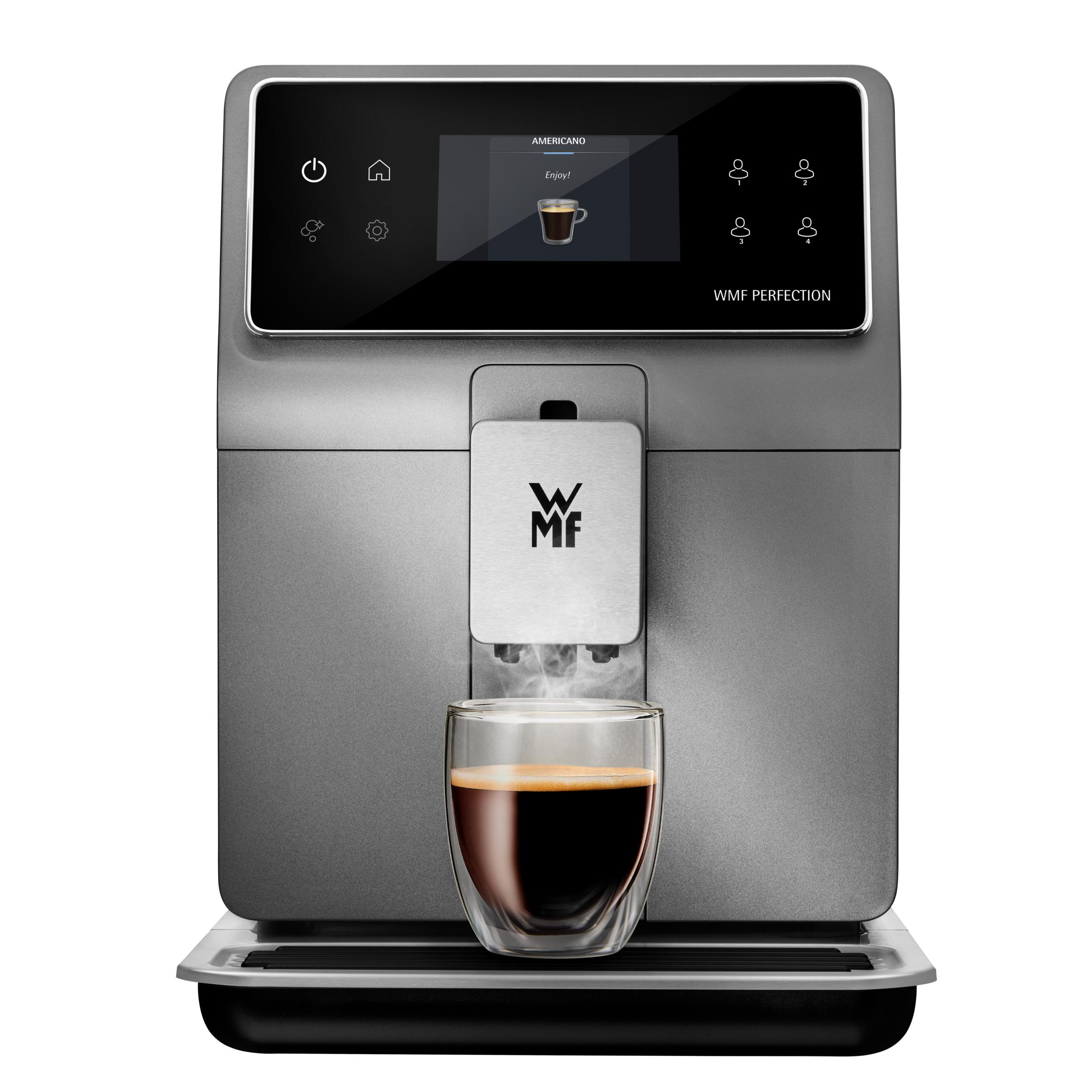 Graue Kaffeemaschine mit Glas, das sich mit Kaffee füllt, Bildschirm zeigt 'AMERICANO'.