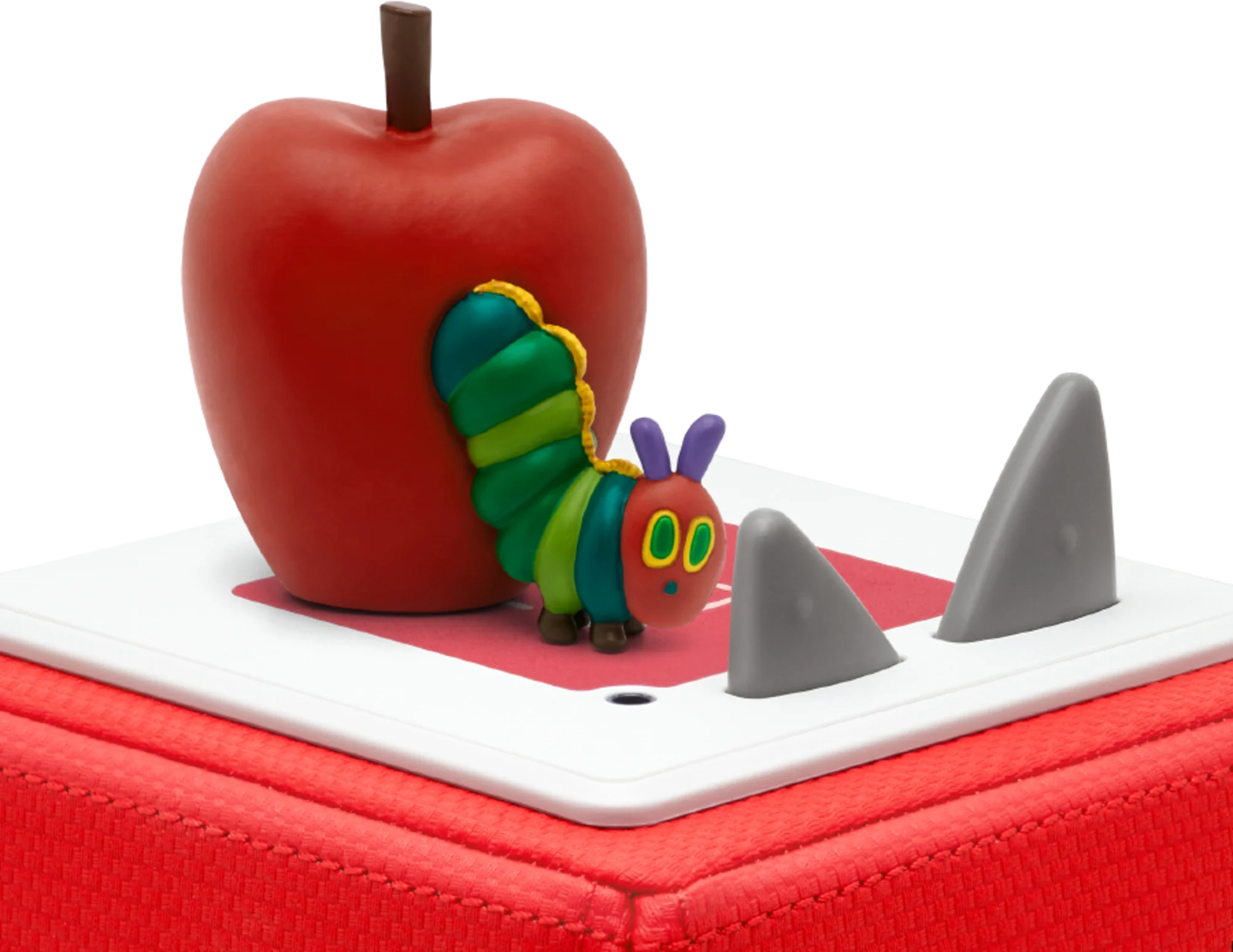 Die kleine Raupe Nimmersatt Spielzeug auf einem roten Würfel mit Apfel und Zähnen.