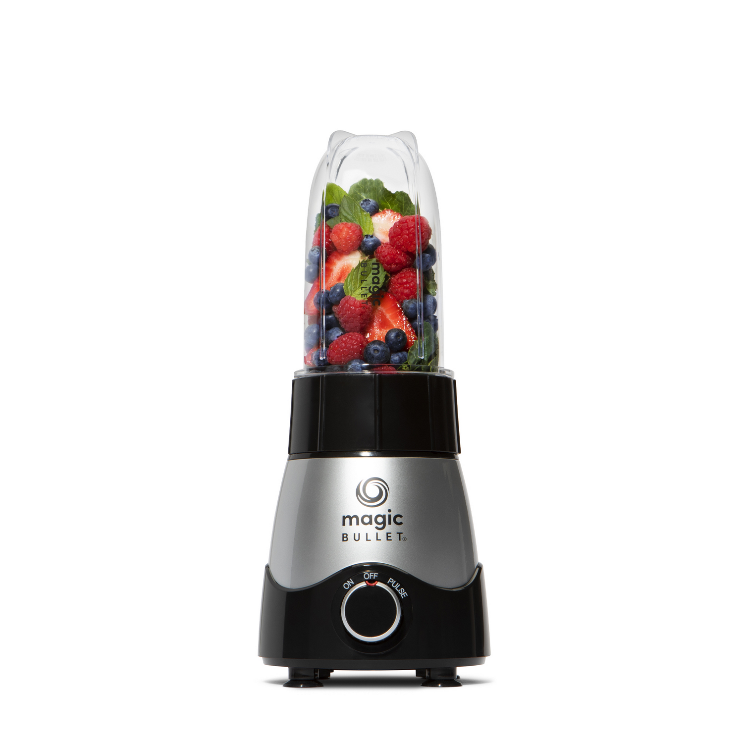 Een Magic Bullet blender gevuld met bessen en groenten, op witte achtergrond.