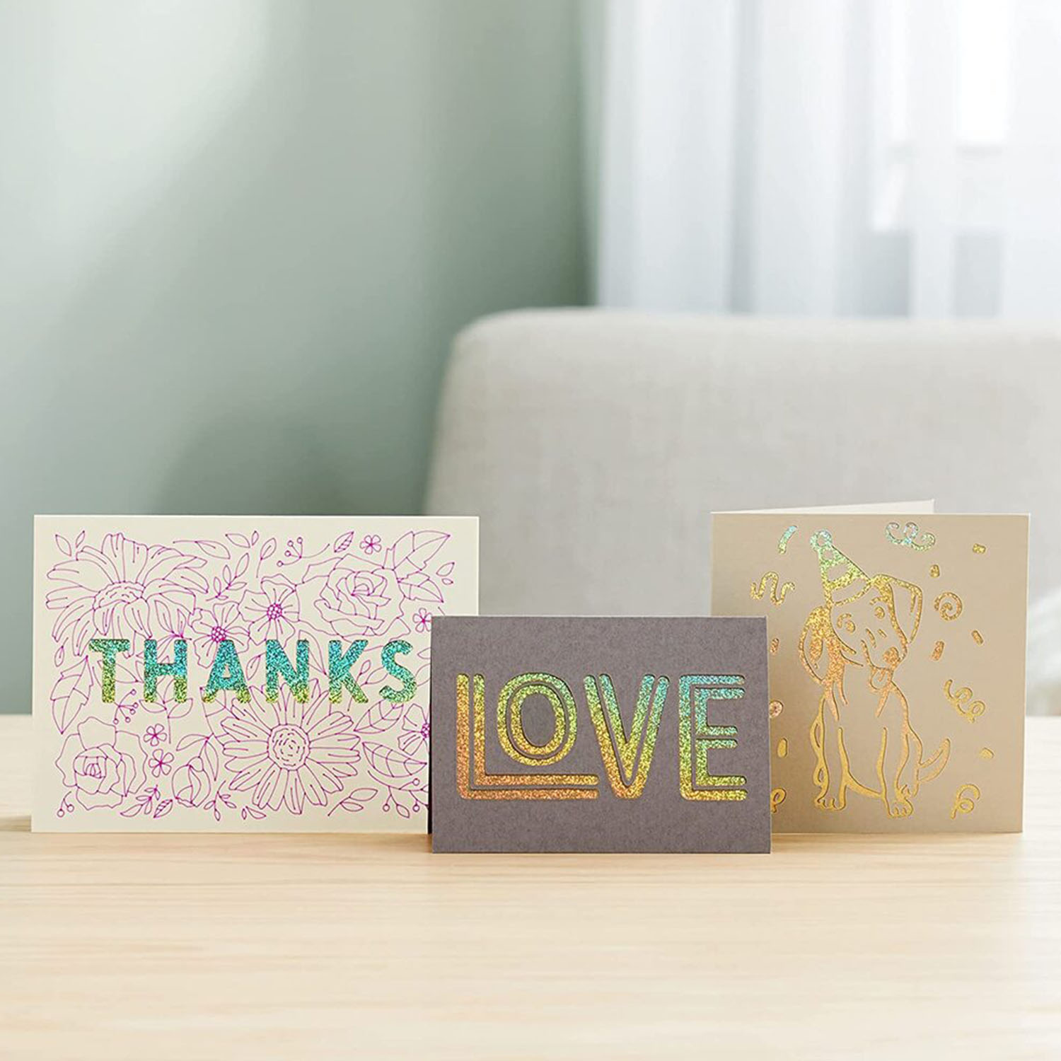 Tre biglietti di auguri con testo glitterato: 'GRAZIE', 'AMORE' e l'immagine di un cane.