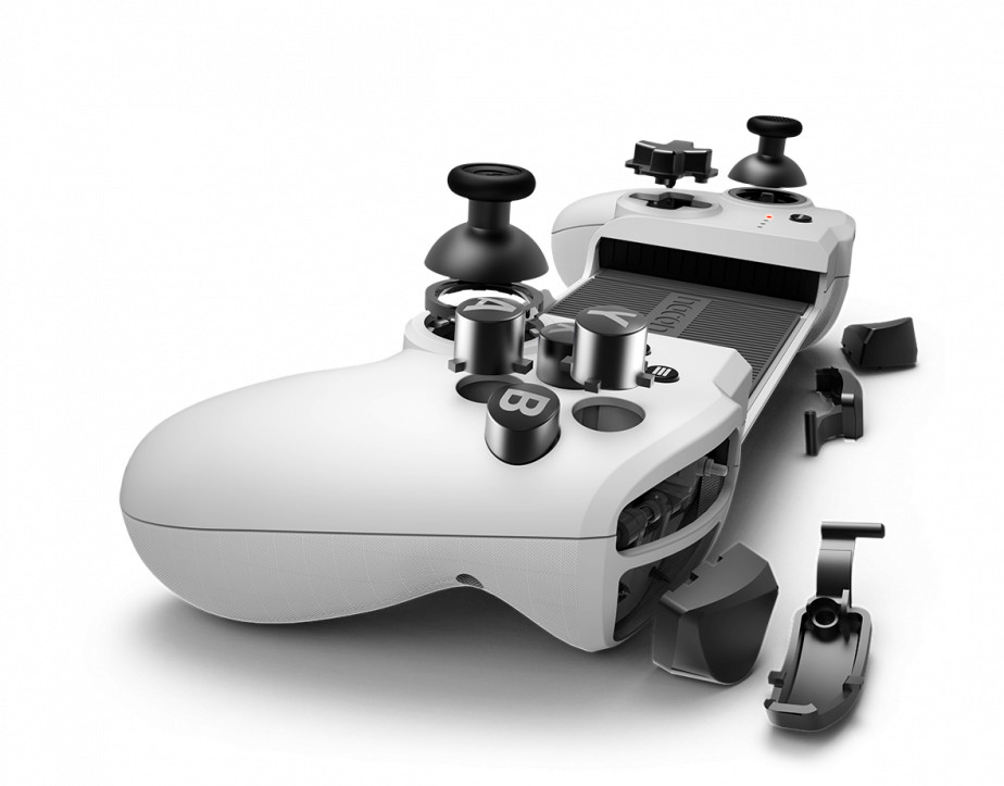 Une manette de jeu blanche démontée avec des boutons, des sticks et des composants éparpillés.
