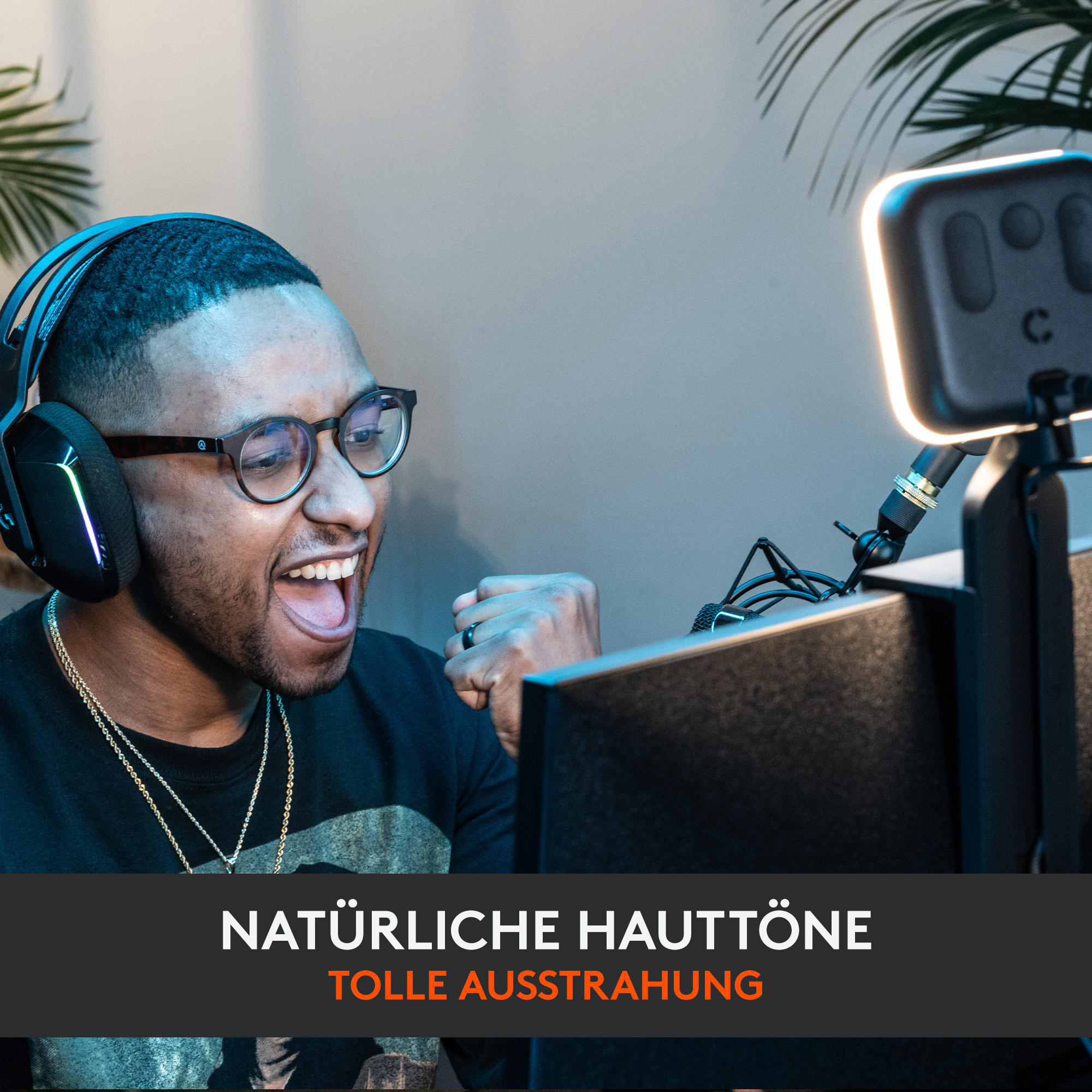 Mann mit Brille und Kopfhörern, der freudig reagiert. Licht und Monitor im Hintergrund.