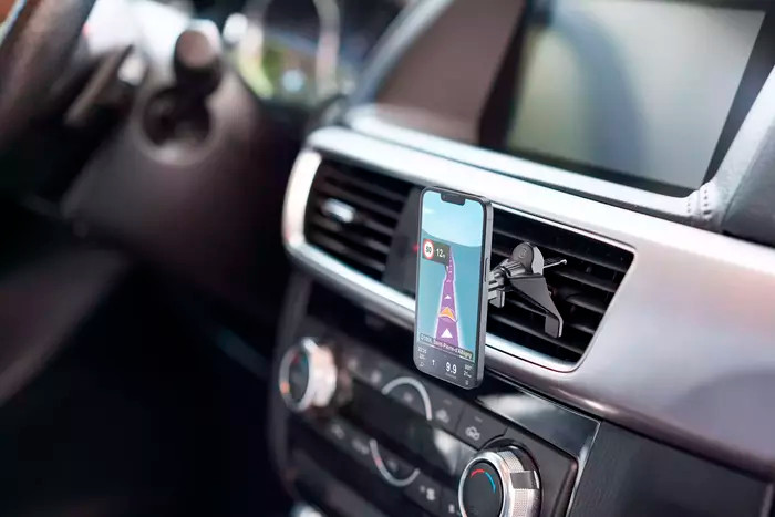Smartphone met navigatie-app gemonteerd op het dashboard van een auto.