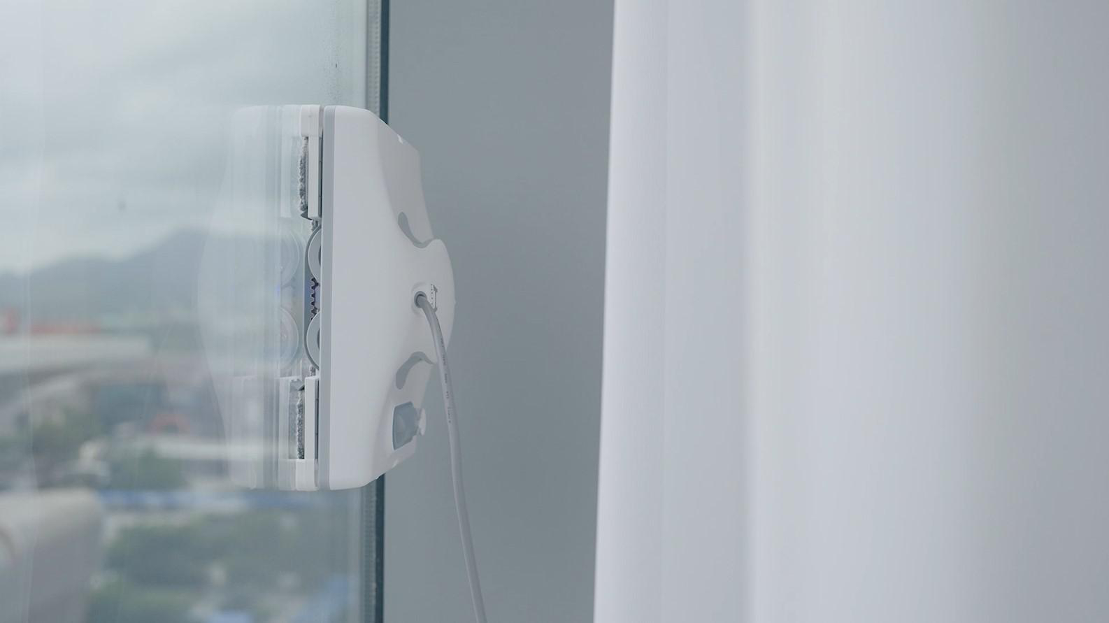 Fensterputzroboter auf Glas, der die Außenseite zeigt.