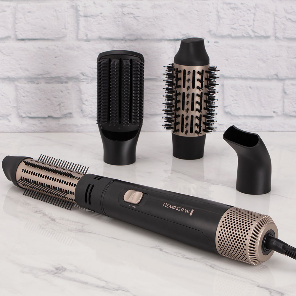 Ein schwarz-goldenes Haarstyling-Werkzeug mit 3 Aufsätzen. Das Werkzeug hat ein Remington-Logo.