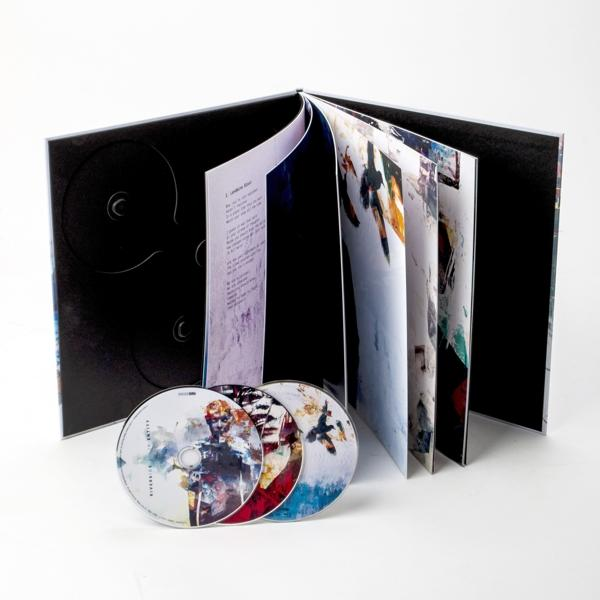 Egy nyitott CD-box szett, látható CD-kkel és füzettel. A műalkotás színes és absztrakt.