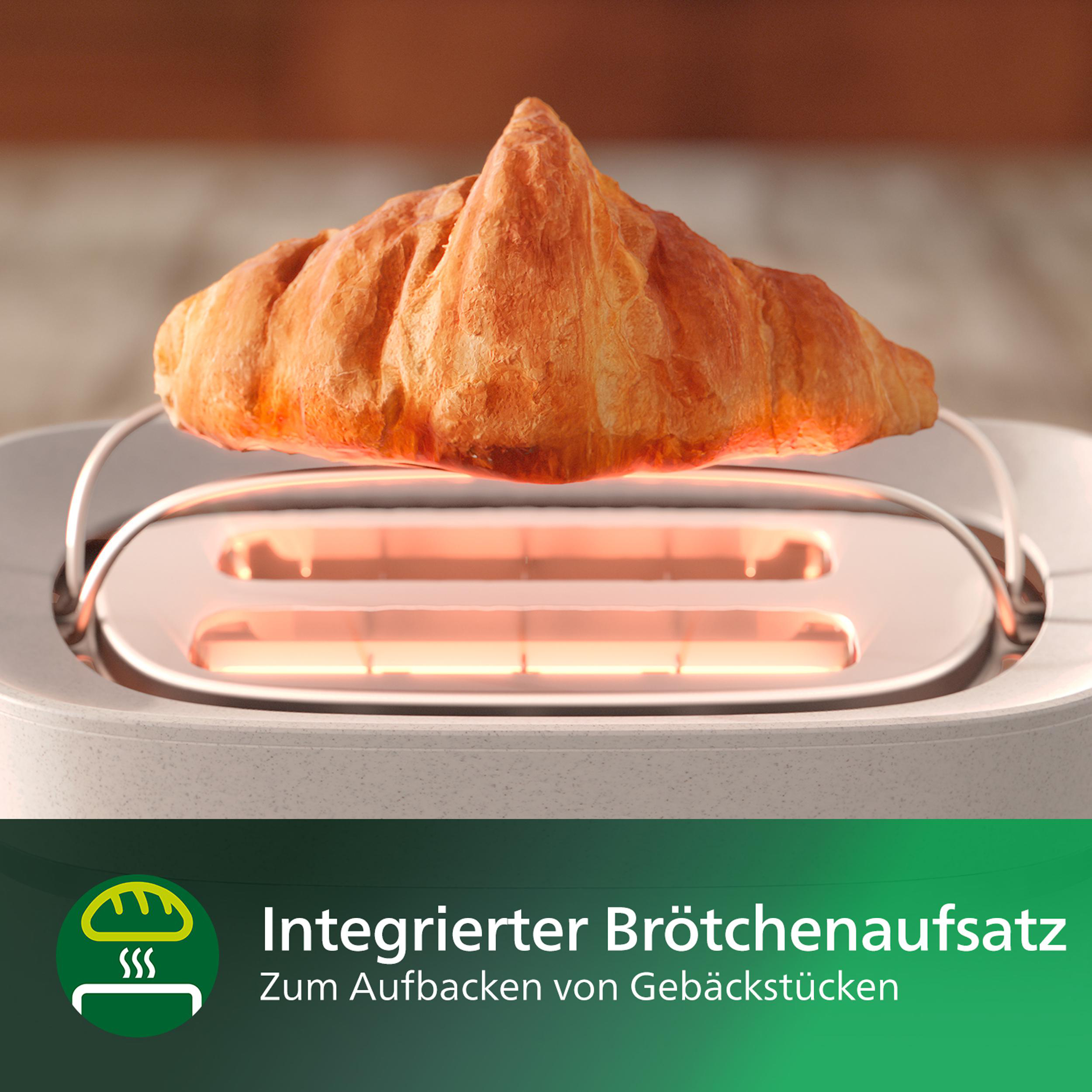 Ein Croissant liegt auf einem Toaster, von innen kommt ein orangefarbener Schein.