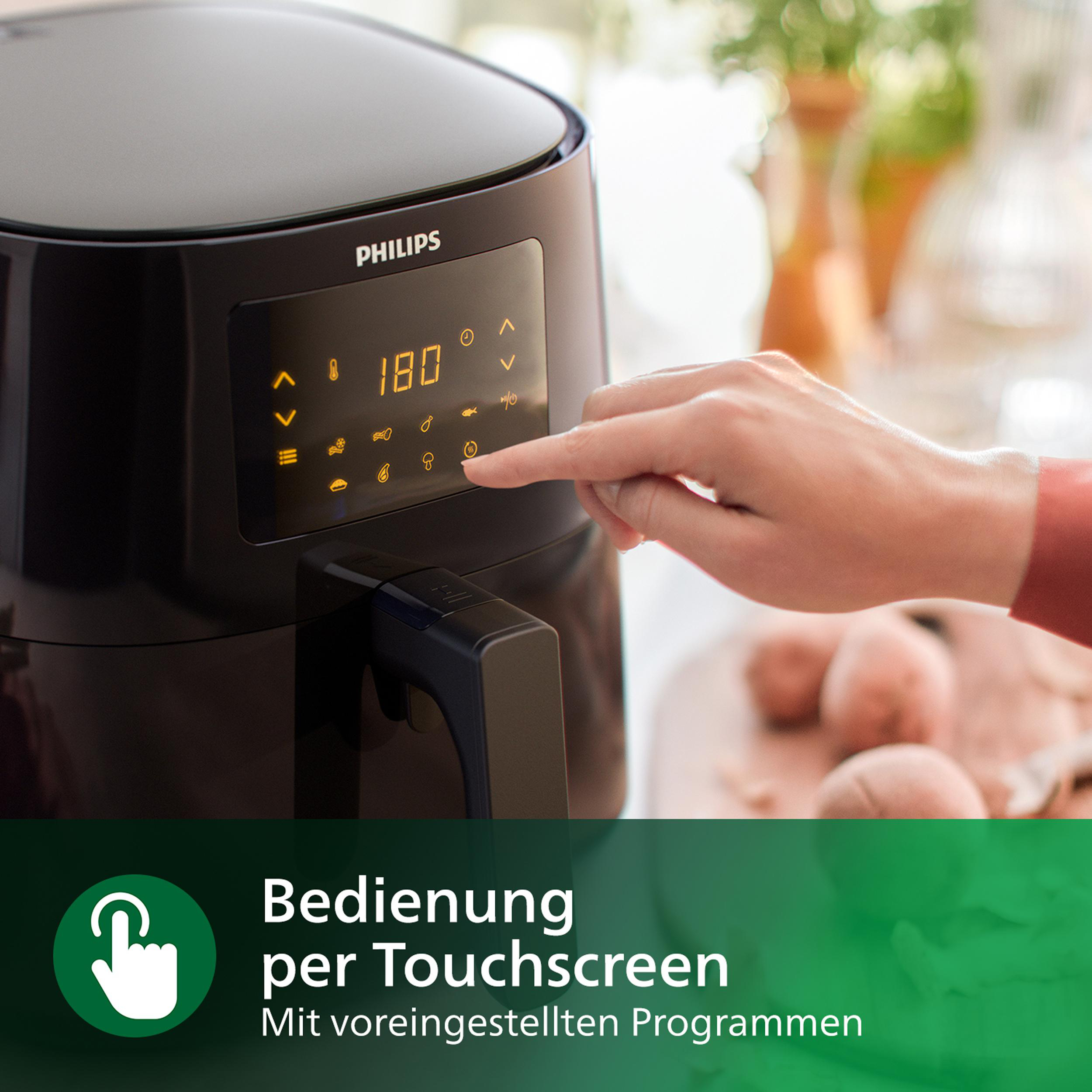 Schwarze Heißluftfritteuse. Eine Hand berührt das Touchscreen-Bedienfeld, Text: 'Bedienung per Touchscreen'.