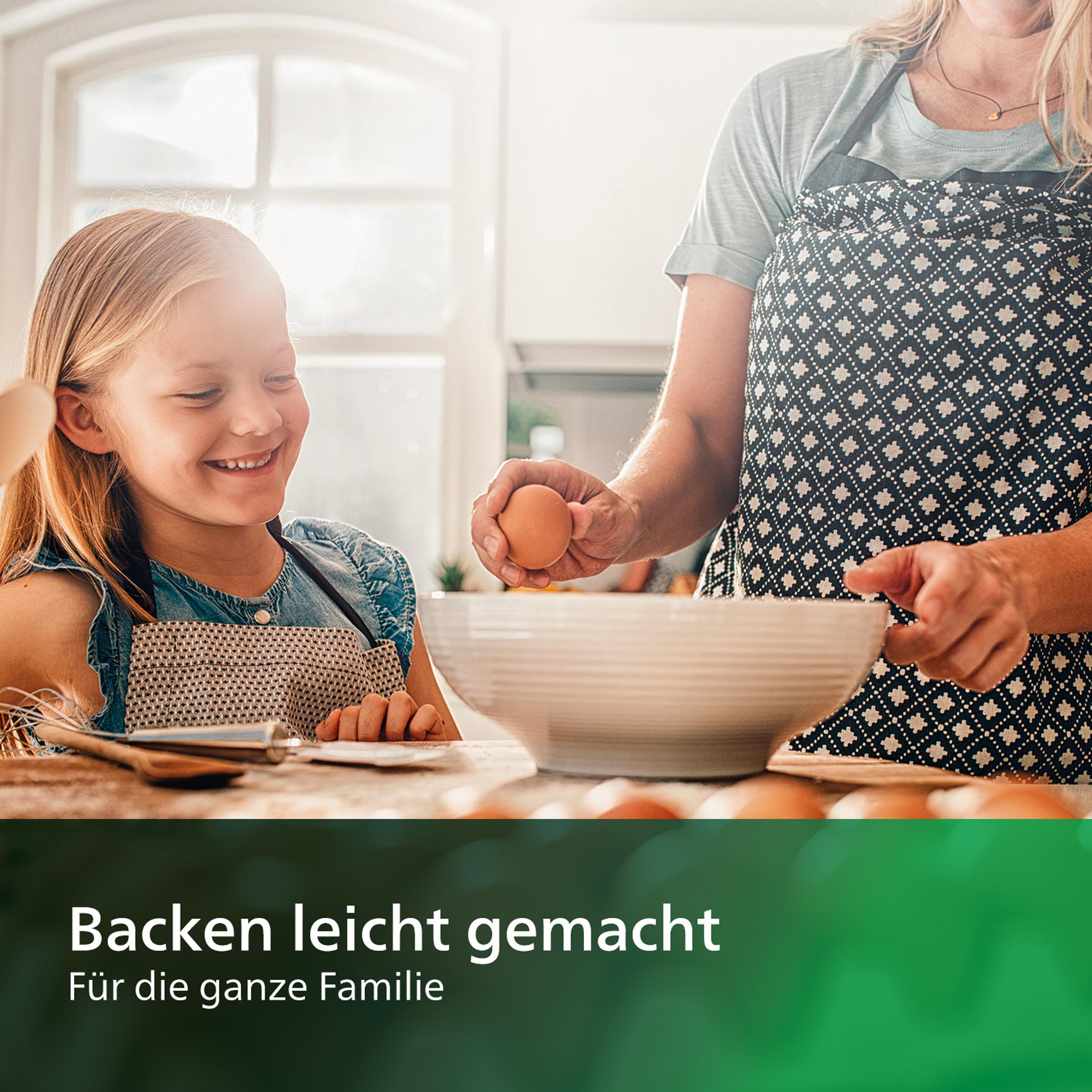 Ein Mädchen und eine Frau backen. Die Frau schlägt ein Ei in eine Schüssel. Sonnenlicht scheint in die Küche.