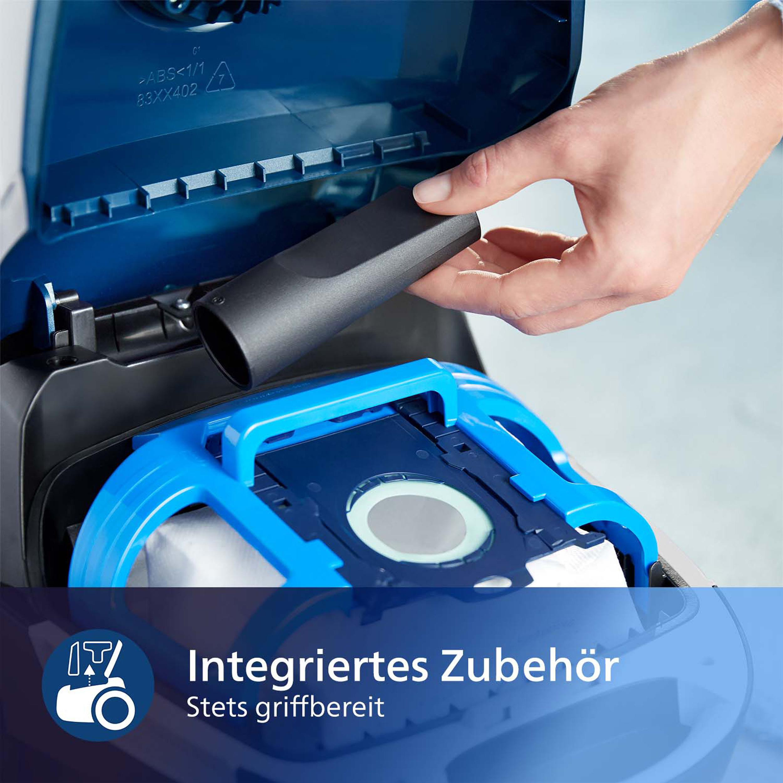 Staubsauger zeigt integriertes Zubehör, eine Hand setzt eine Düse ein, blau und weiß.