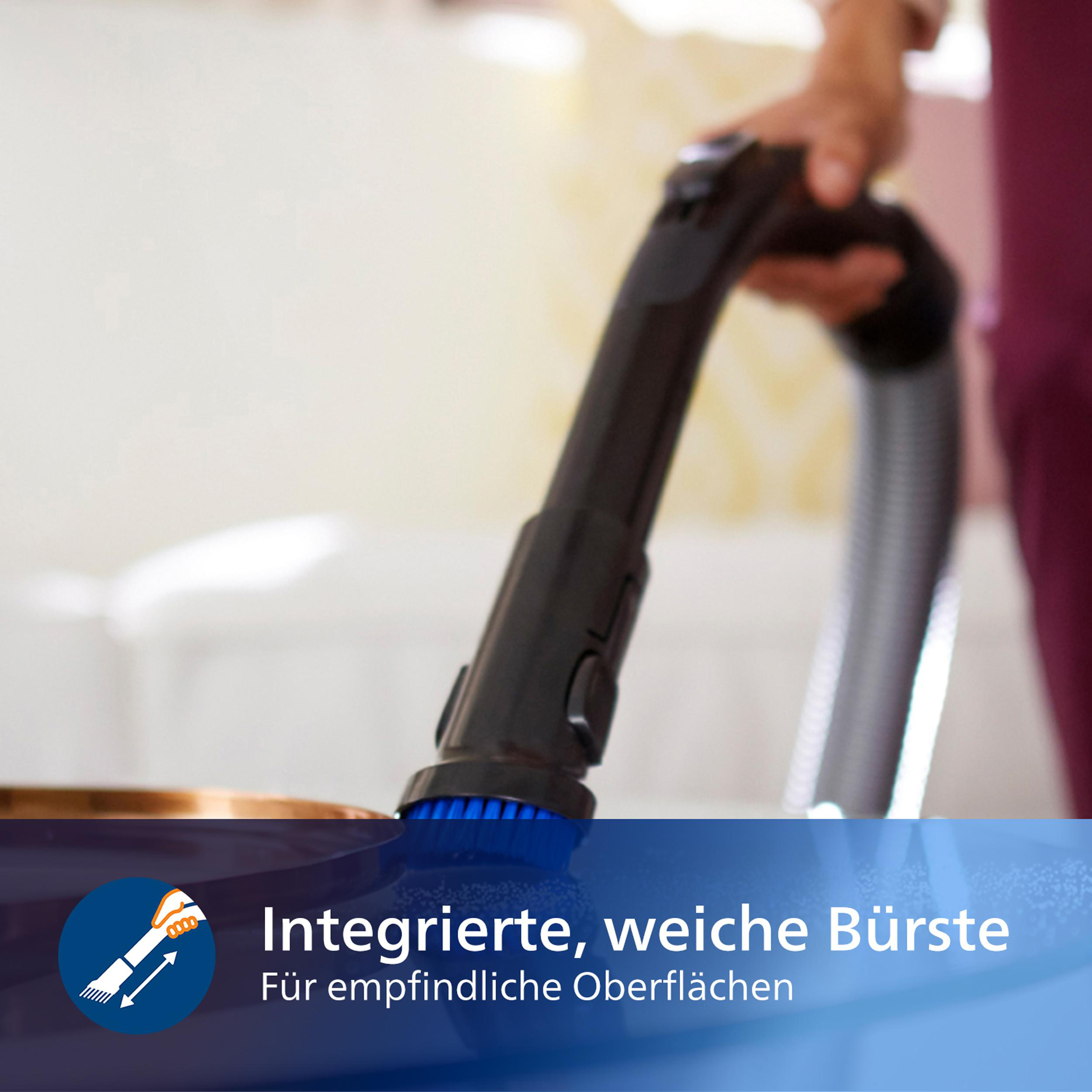 Eine Hand, die einen Staubsauger mit einer blauen Bürste zum Reinigen einer Oberfläche verwendet.