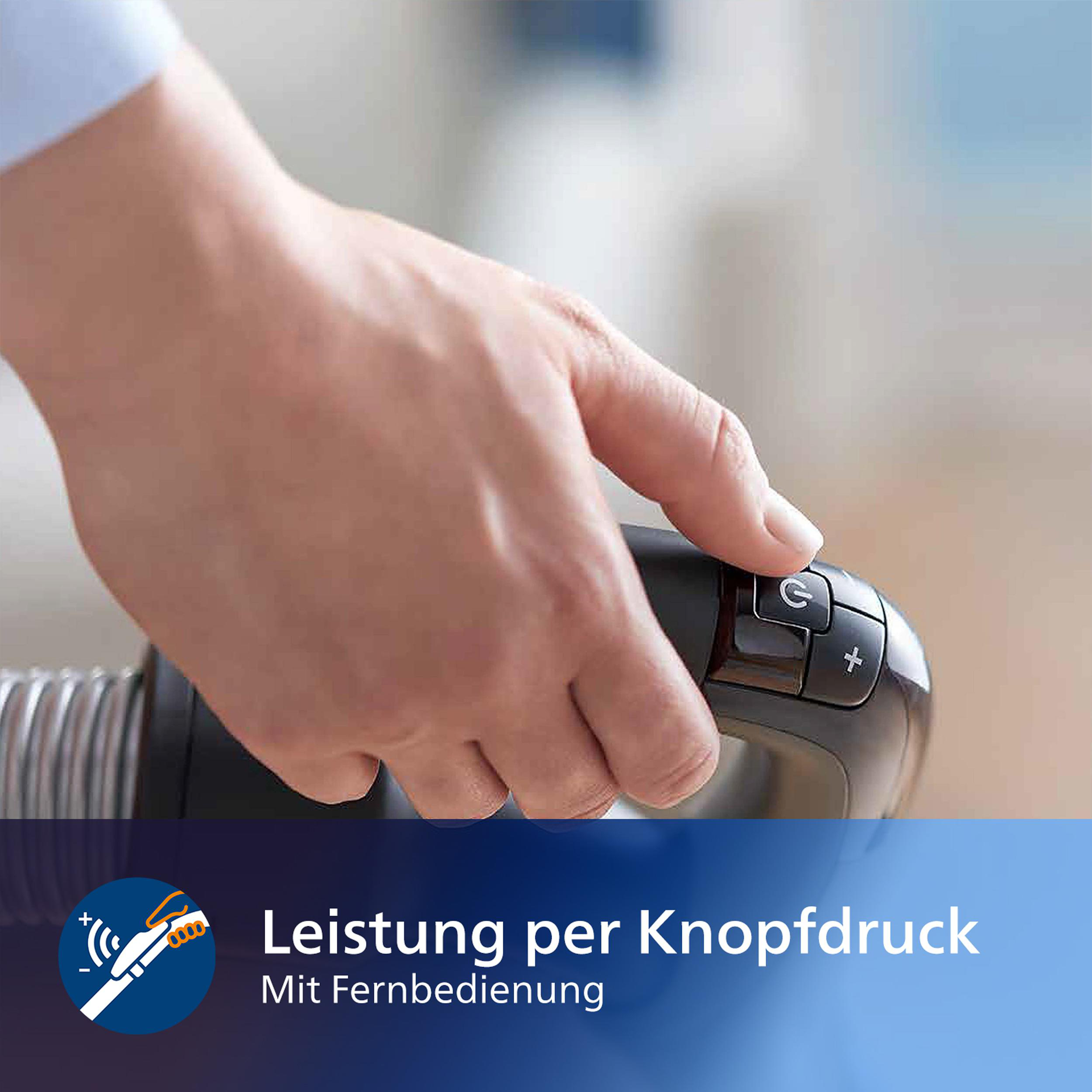 Eine Hand schaltet einen Staubsauger ein. Das Bild enthält Text mit der Aufschrift 'Leistung per Knopfdruck'.