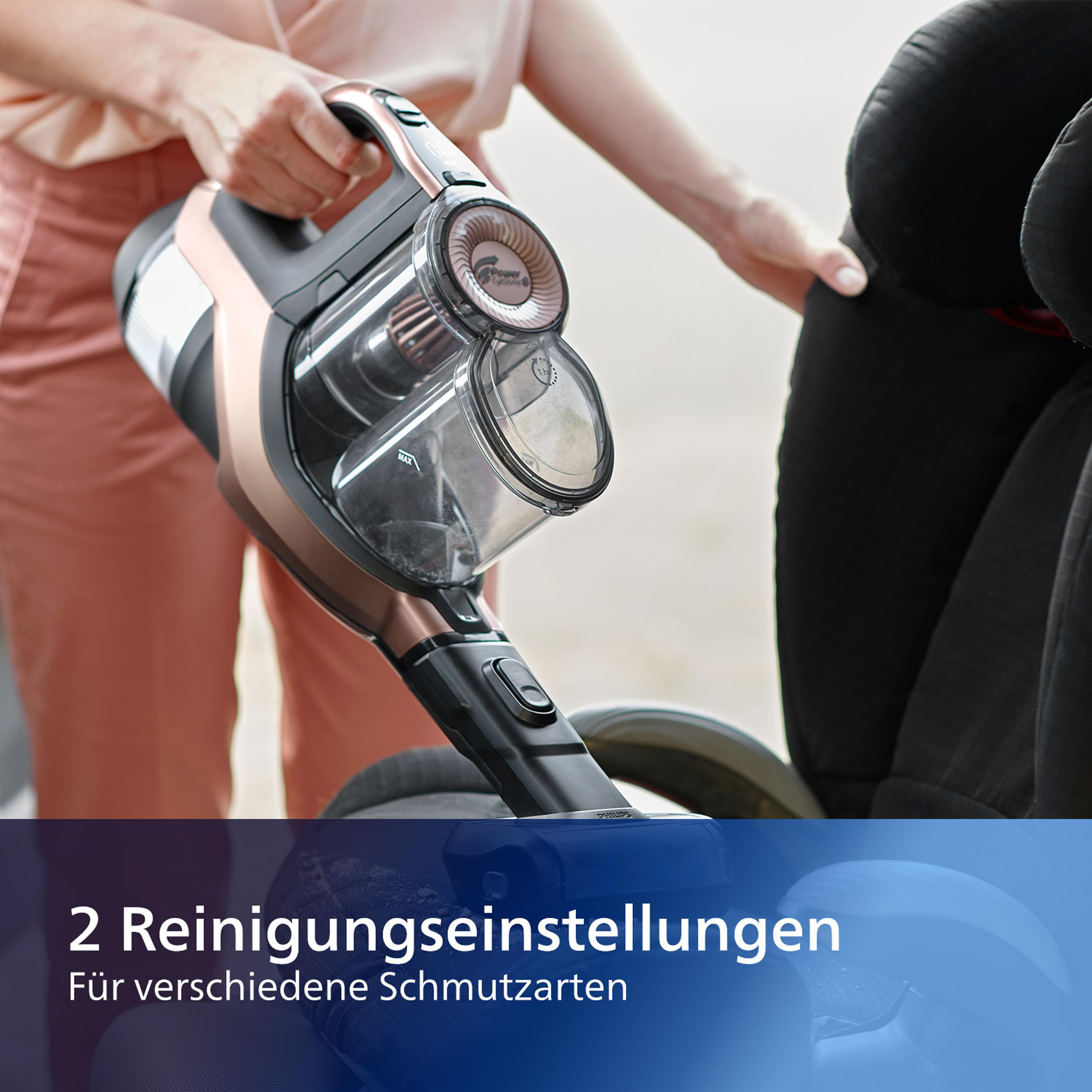 Eine Person hält einen Staubsauger neben einem Kinderwagen. Der Text auf dem Bild lautet: „2 Reinigungseinstellungen.