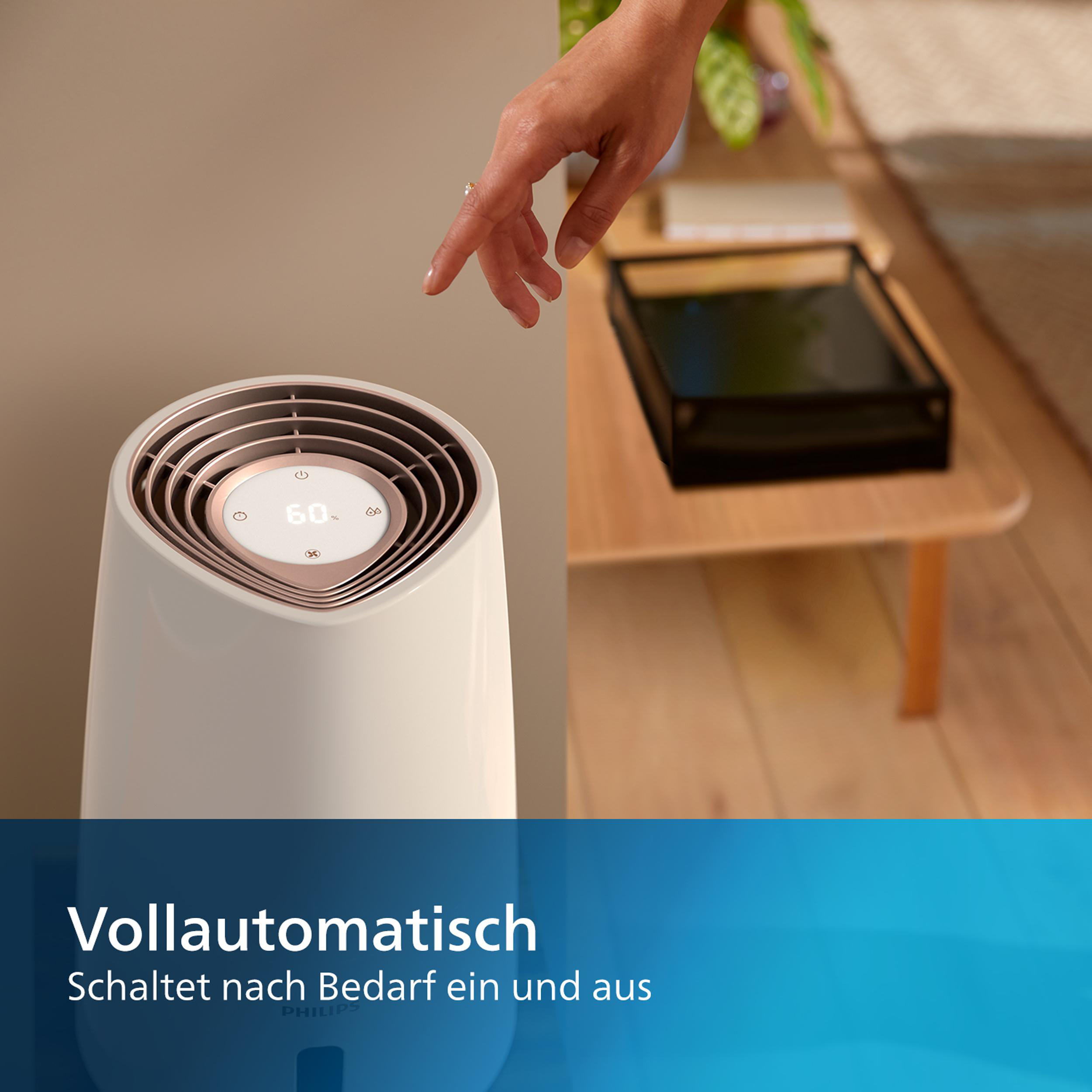 Weiß-beiger Luftreiniger, Hand berührt Bedienfeld, neben Tisch.