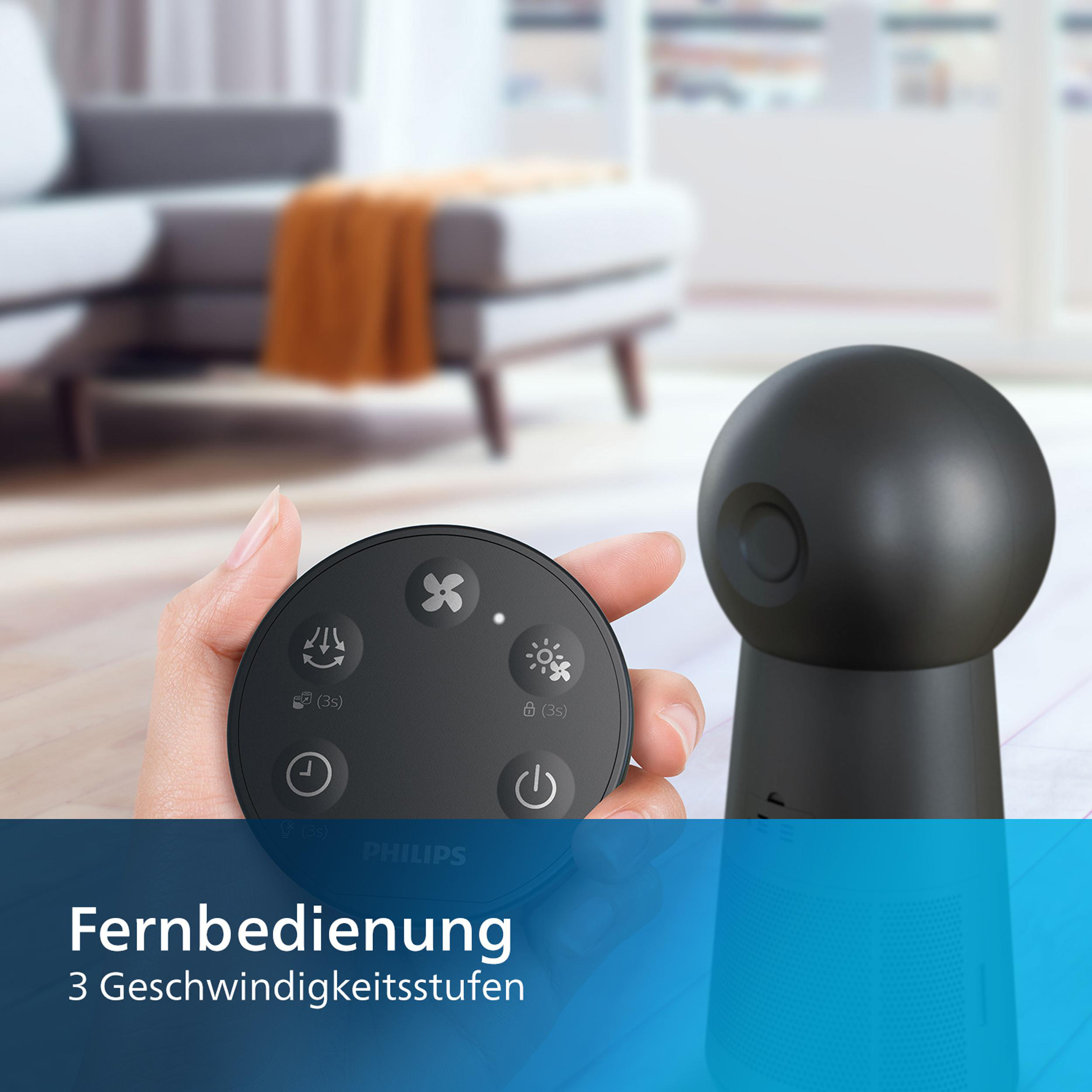 Eine Frau hält eine Fernbedienung für ein Philips-Gerät. Ein schwarzes Gerät steht auf einem Tisch. Das Wort lautet 'Fernbedienung'.