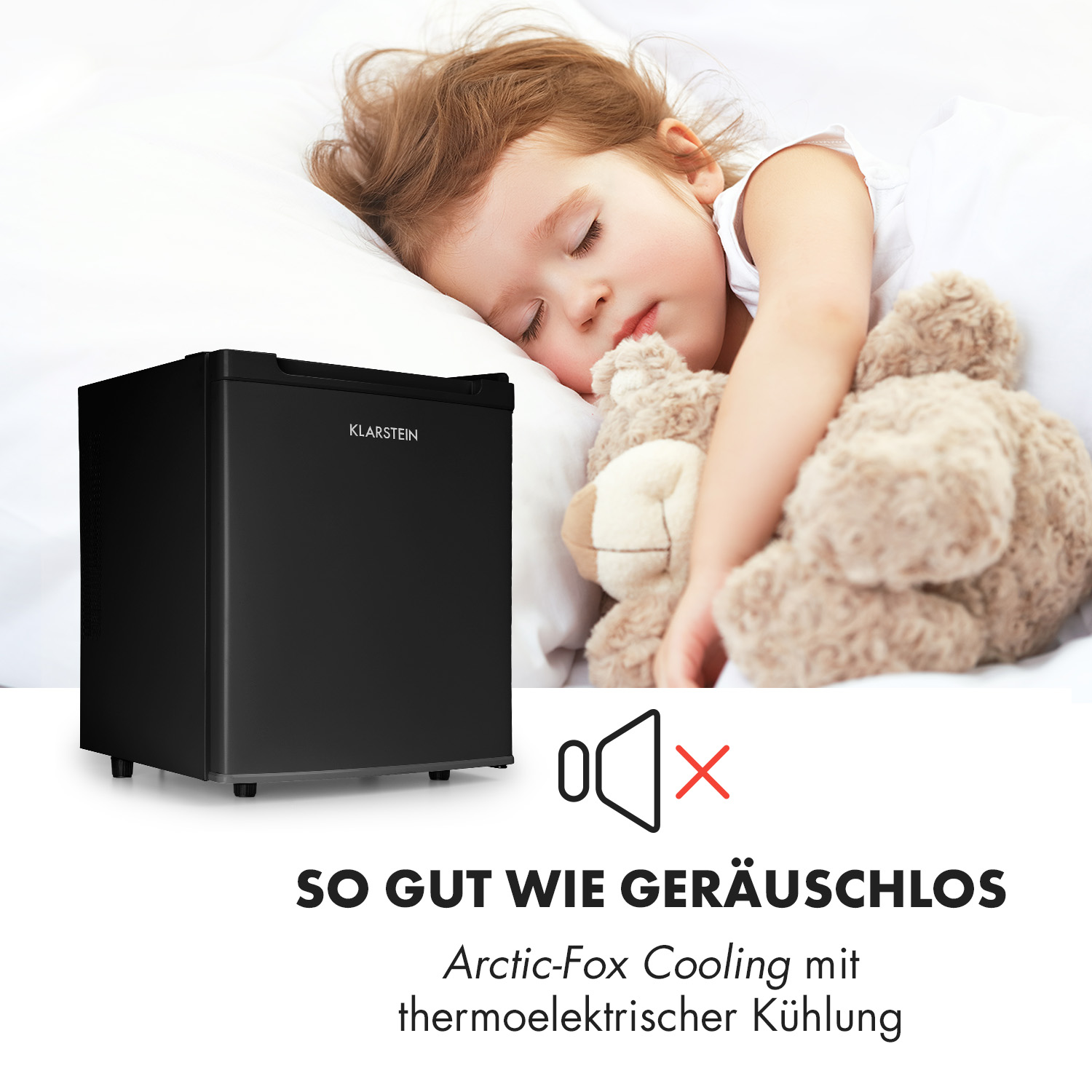 Schlafendes Kind mit Teddybär neben kleinem schwarzen Kühlschrank. Text: Leise.