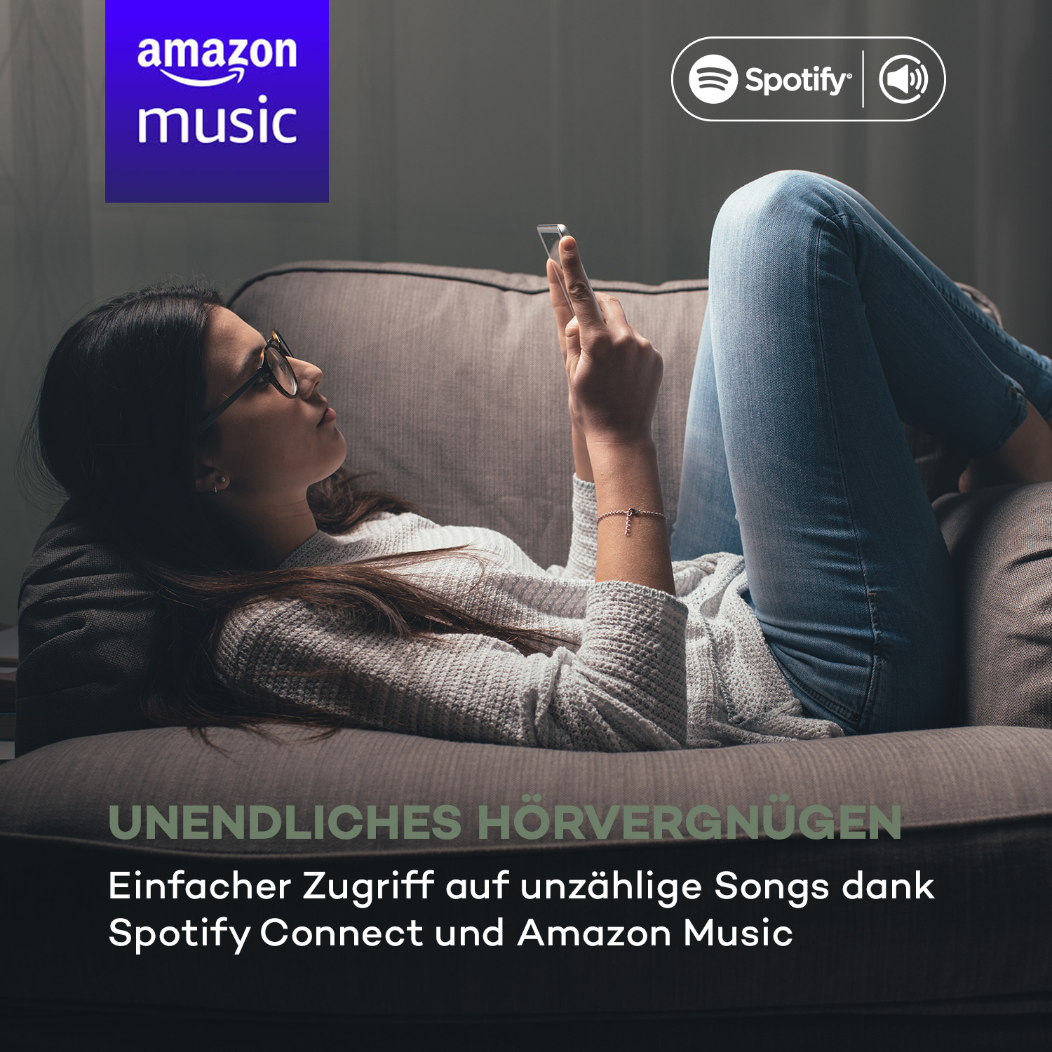 Frau auf Couch, hört Musik auf dem Handy. Amazon Music und Spotify Logos vorhanden.
