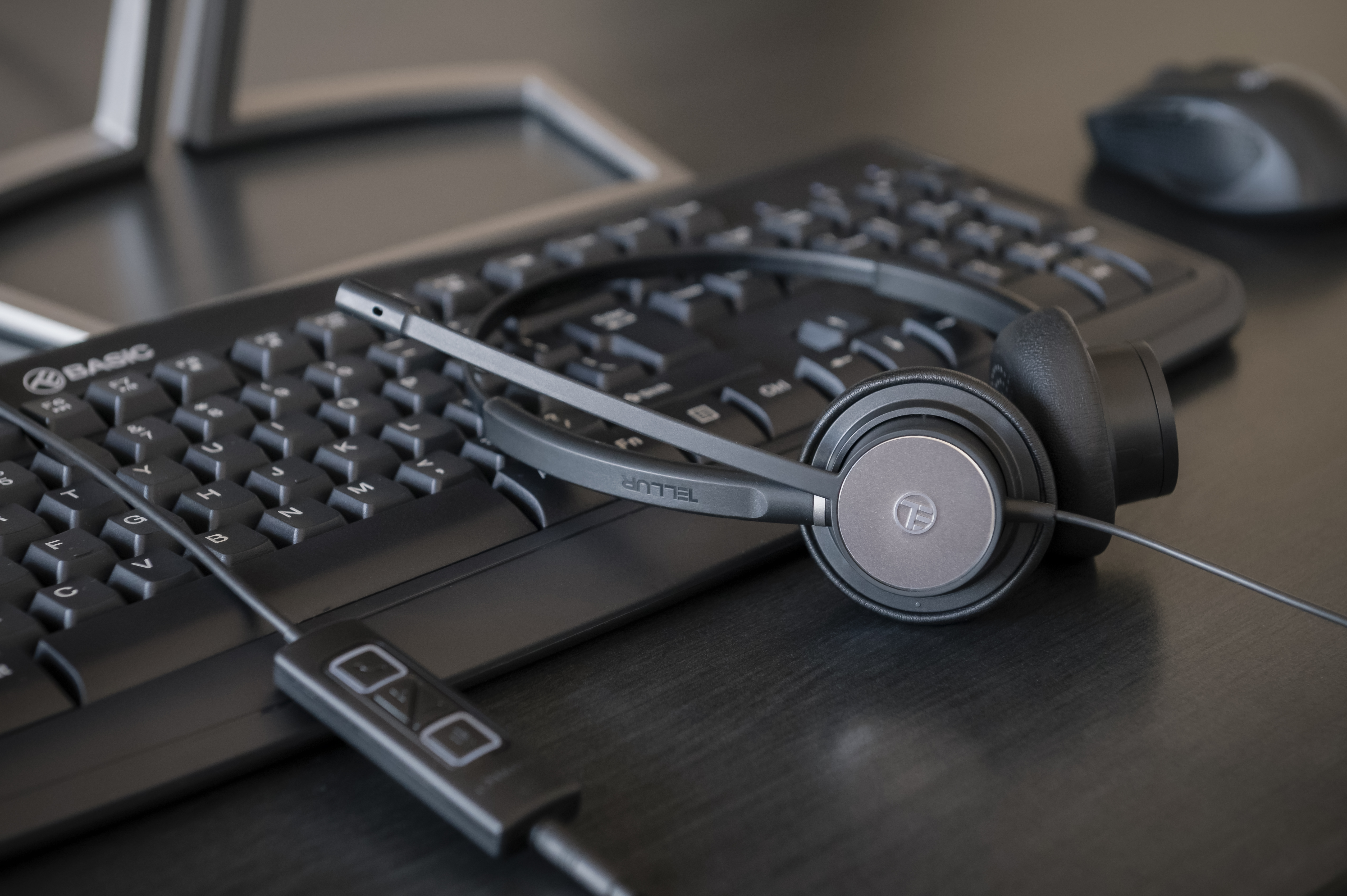 Zestaw słuchawkowy na klawiaturze. Czarny zestaw słuchawkowy z mikrofonem, klawiatura.