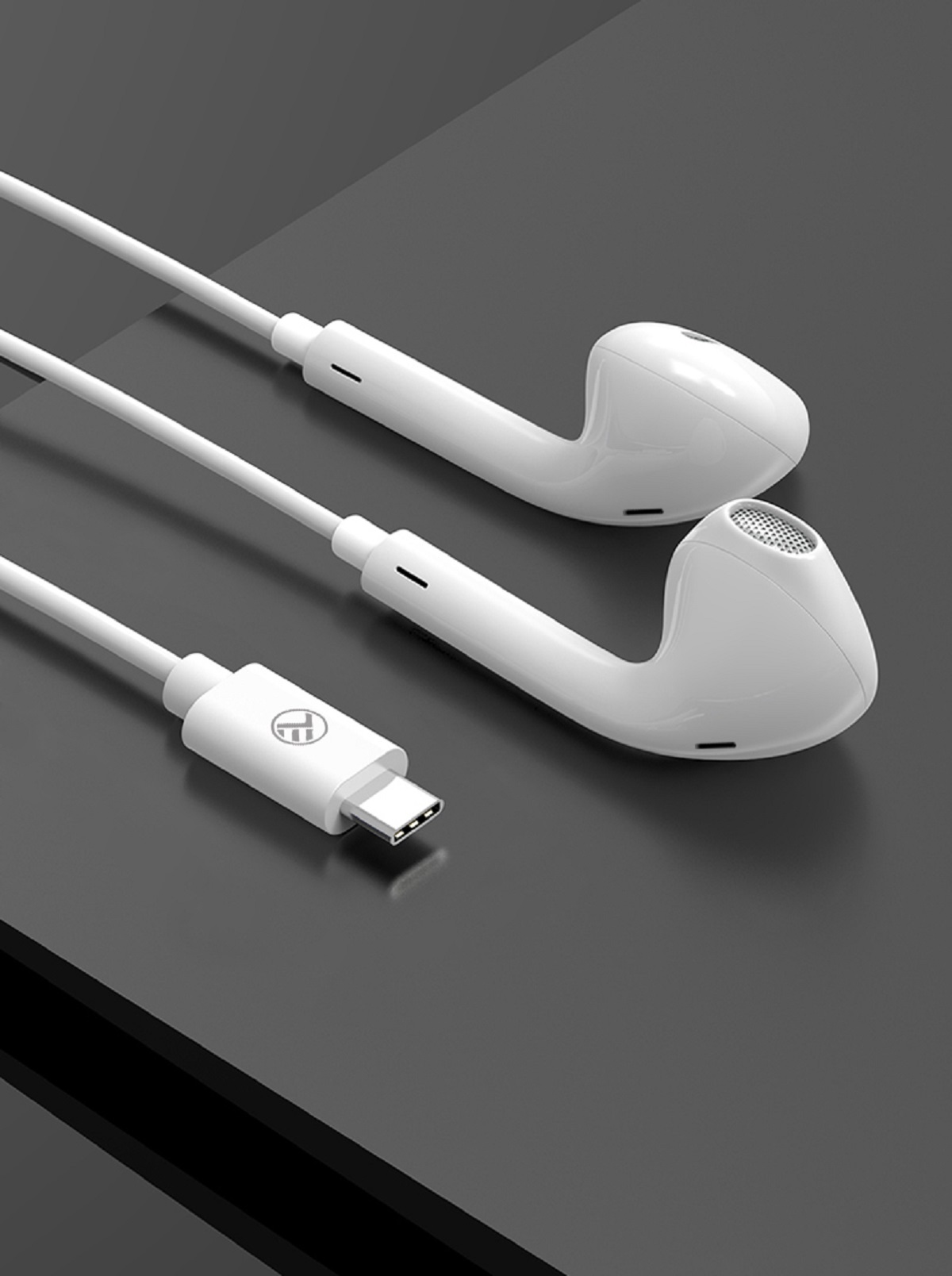Białe słuchawki z złączem USB-C na ciemnej powierzchni.