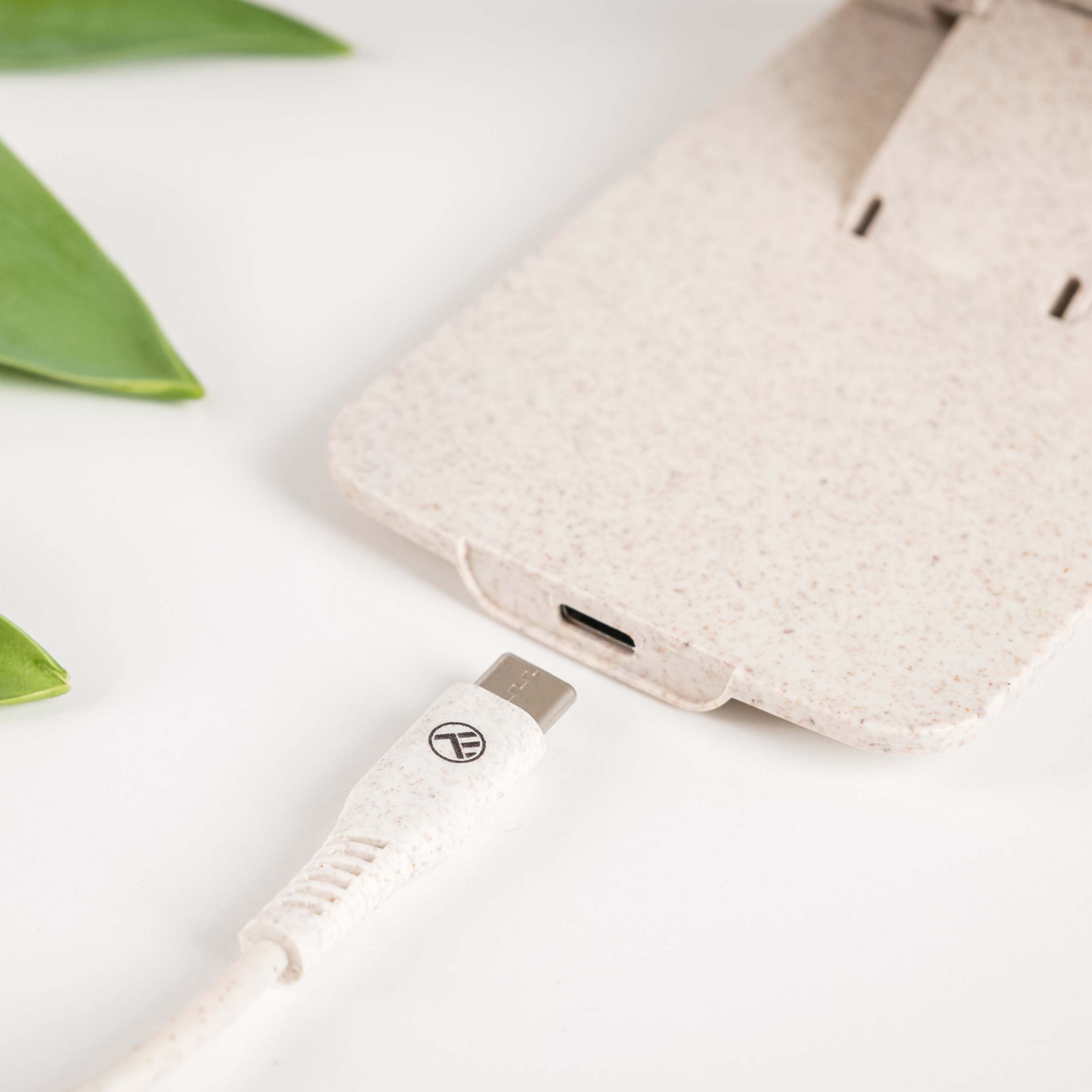 Eine Handyhülle mit eingestecktem USB-C-Kabel. Die Hülle ist beige und das Kabel cremefarben.
