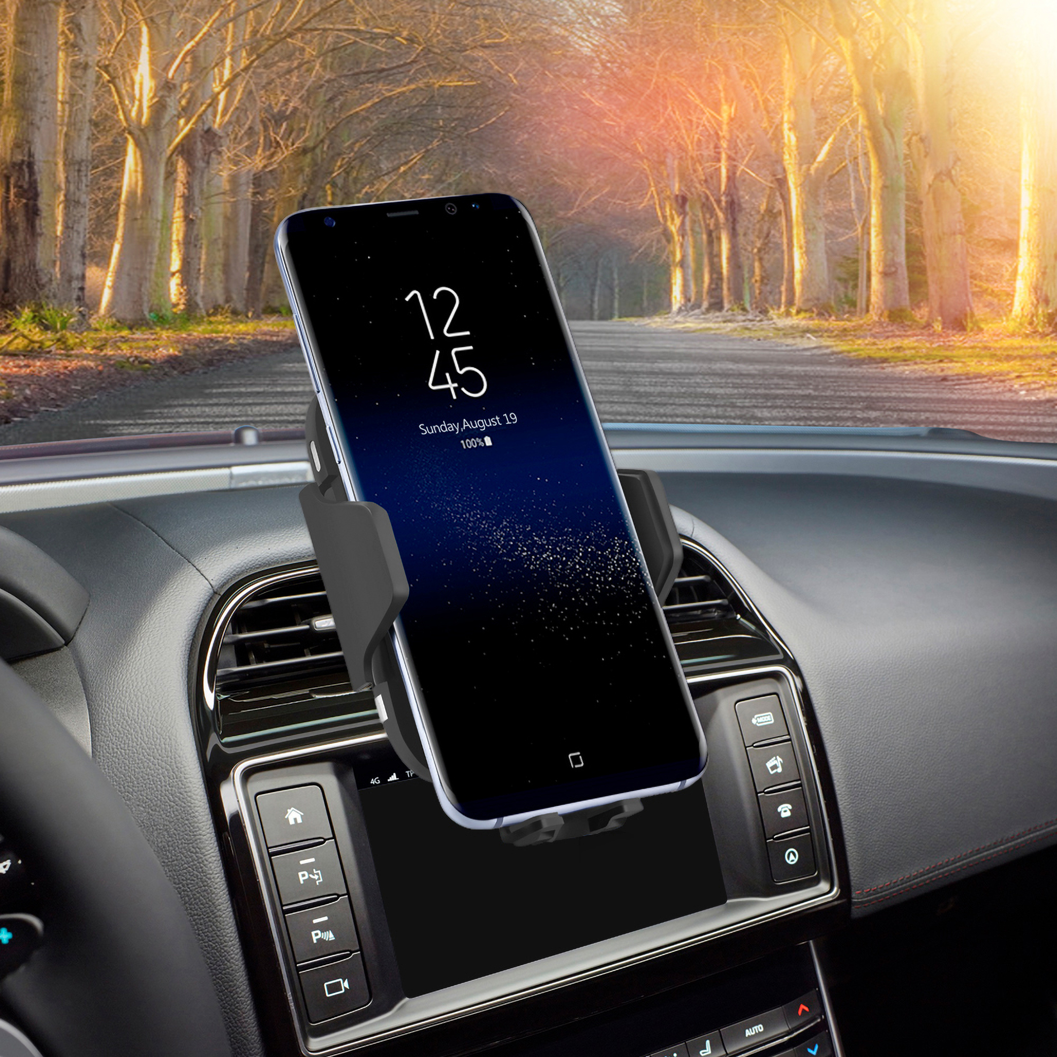 Un teléfono montado en el salpicadero de un coche, mostrando la hora y la fecha, con una carretera visible.
