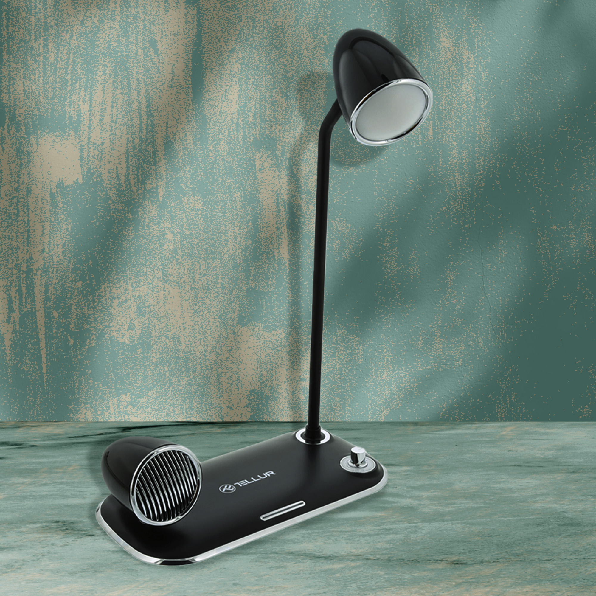 Czarna lampa biurkowa z podstawą głośnika. Stoi na drewnianej powierzchni.