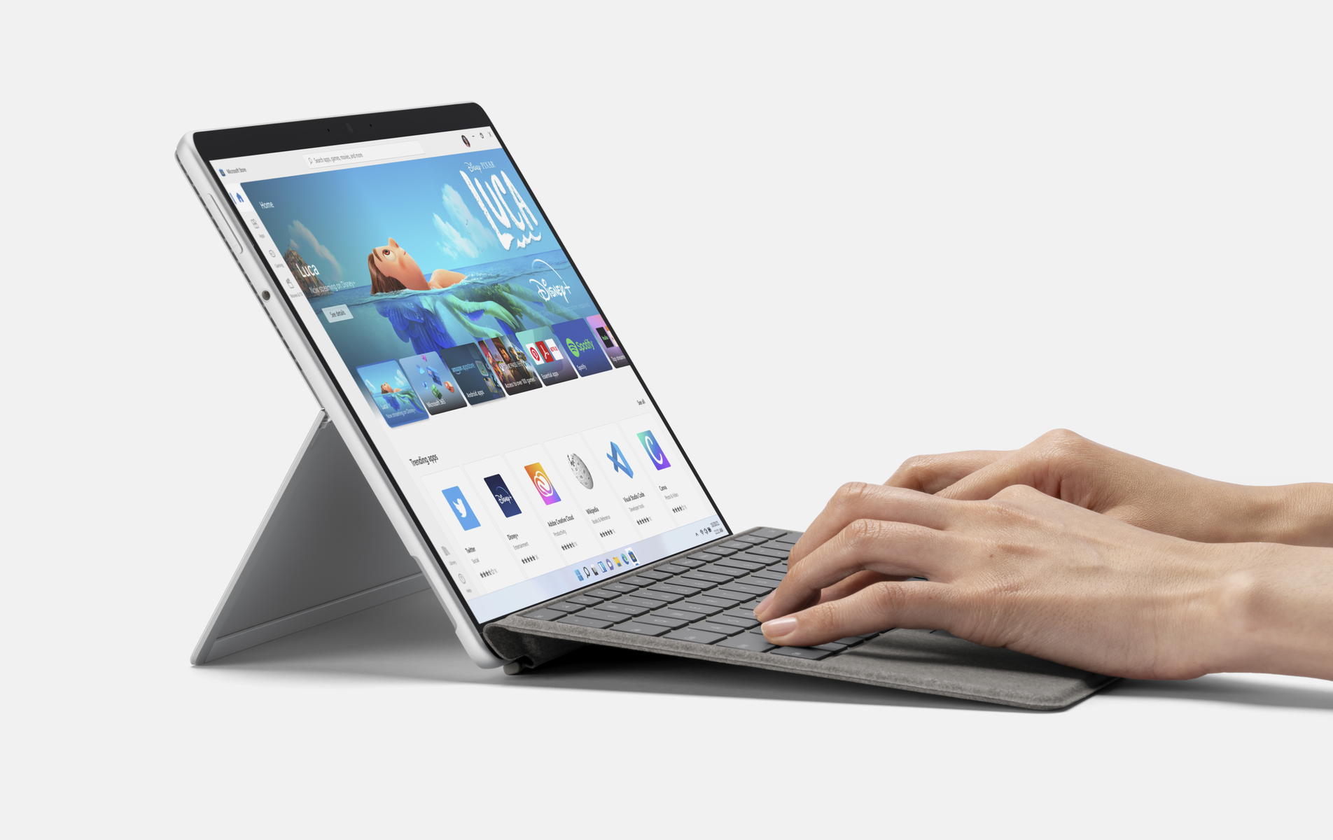 Laptop con tastiera, mostra un sito web, mani di persona sulla tastiera.